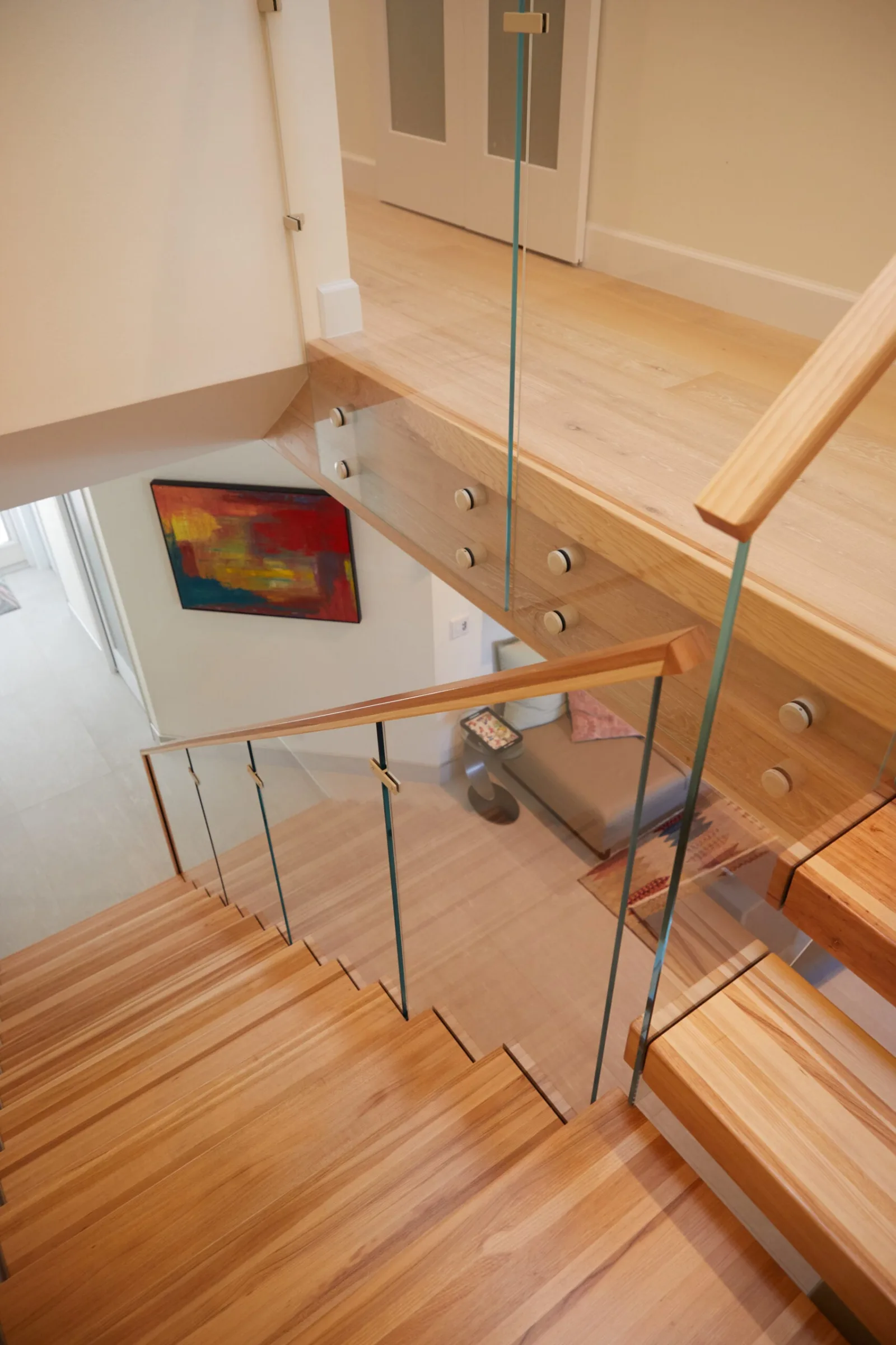 Steep downward angle showing glass standoff pins along the upper landing rail