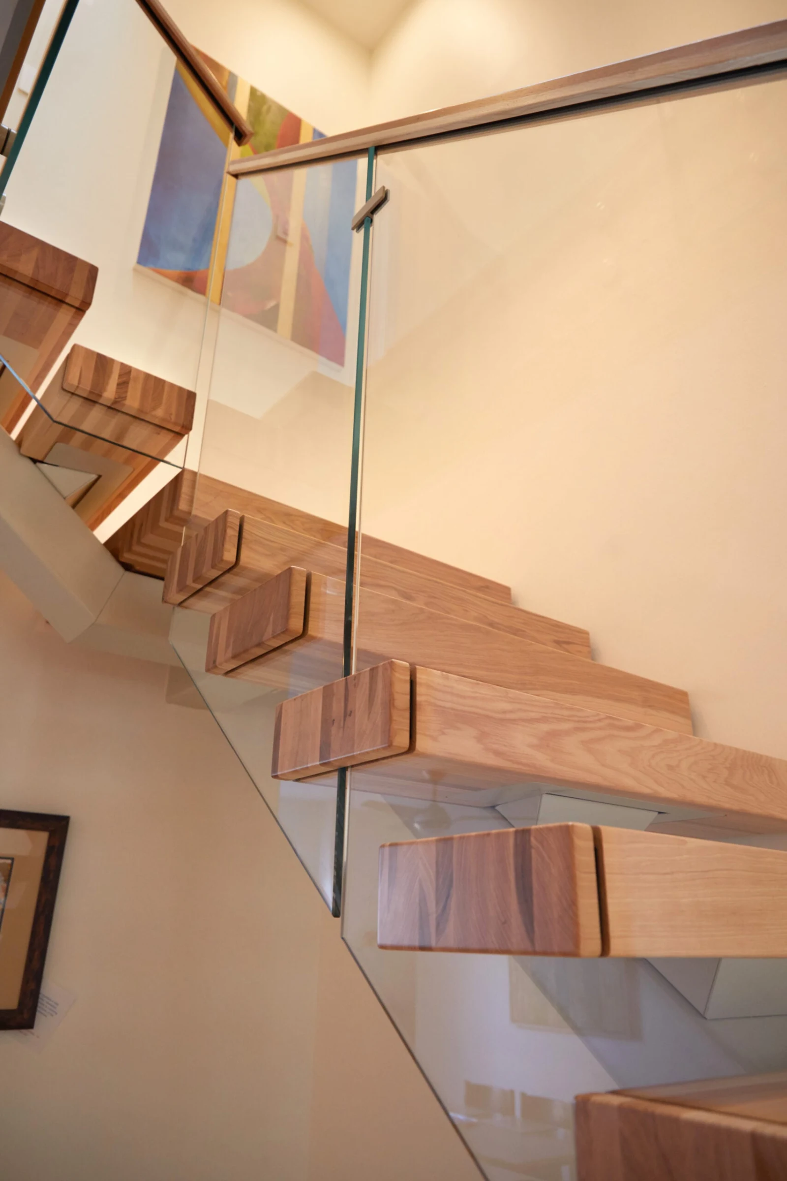 Upward view beneath the treads through the glass railing toward the landing