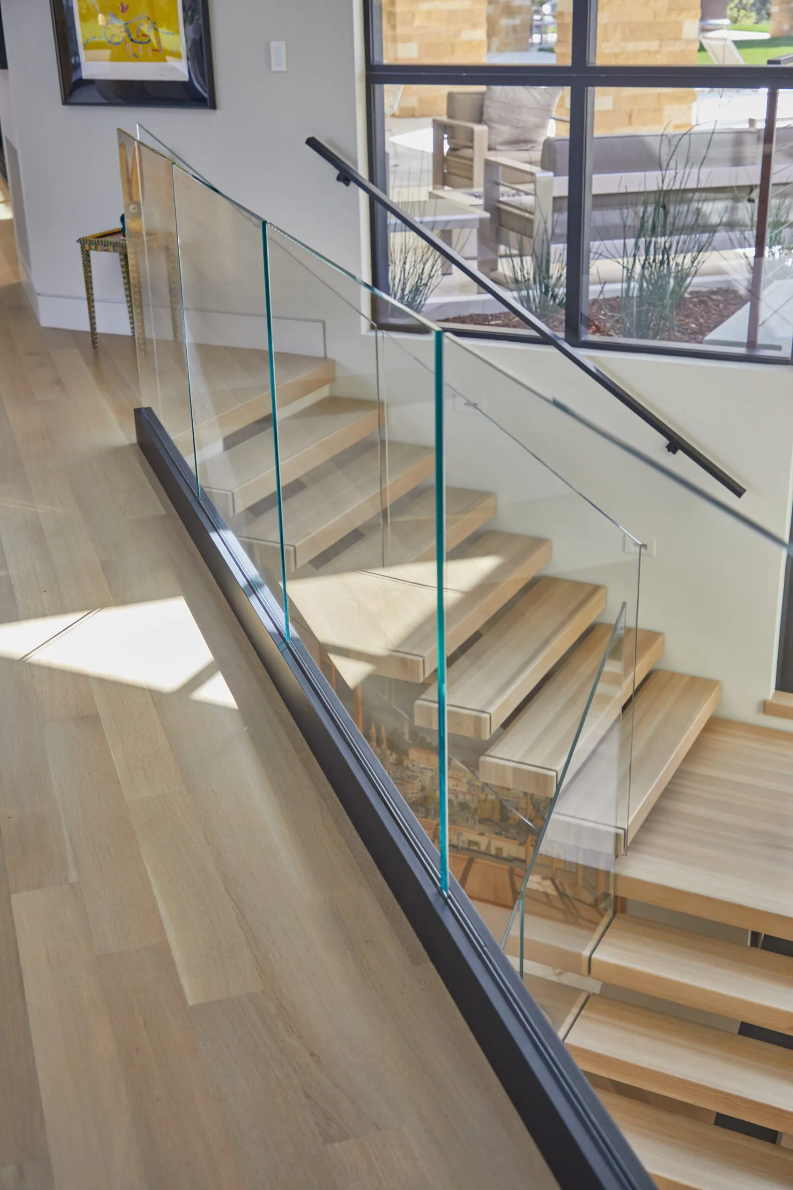 Glass railing in a black base channel along the upper floor overlook