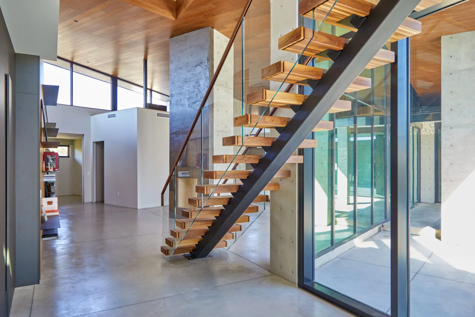 Open living area with the flight rising against a concrete column