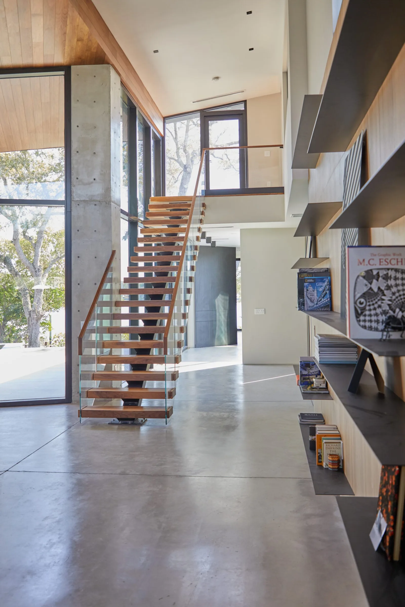 Long hallway leading toward the stair over polished concrete flooring
