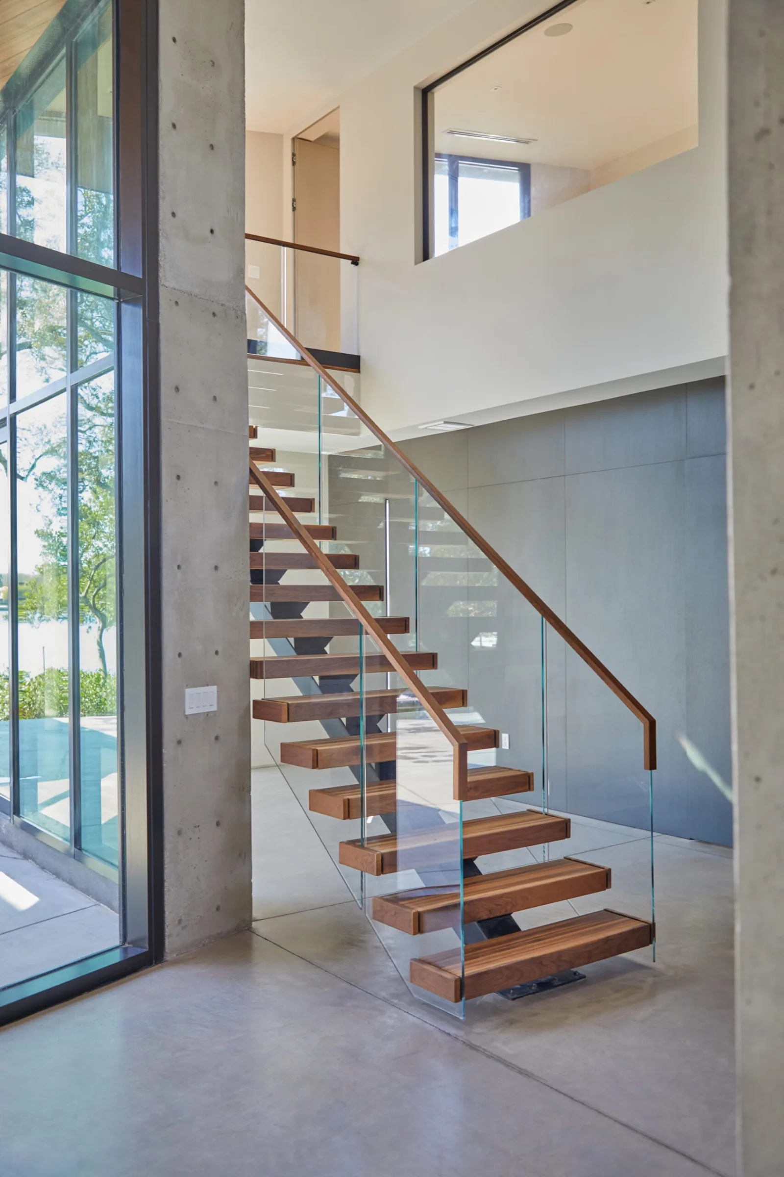 Flight framed between a concrete column and a full-height window