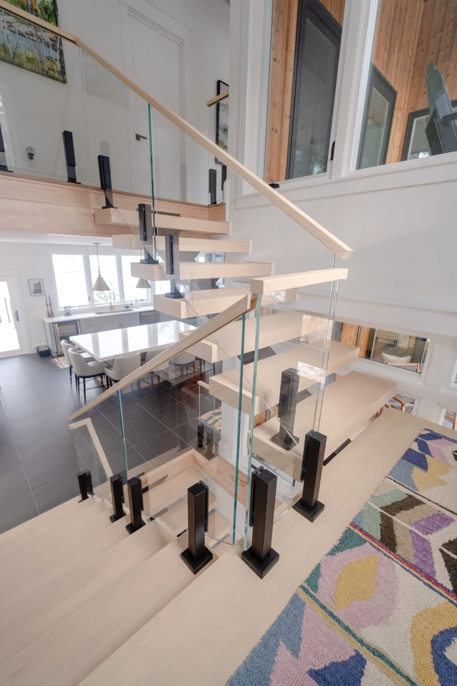Looking down from the landing over glass panels held by black clamps