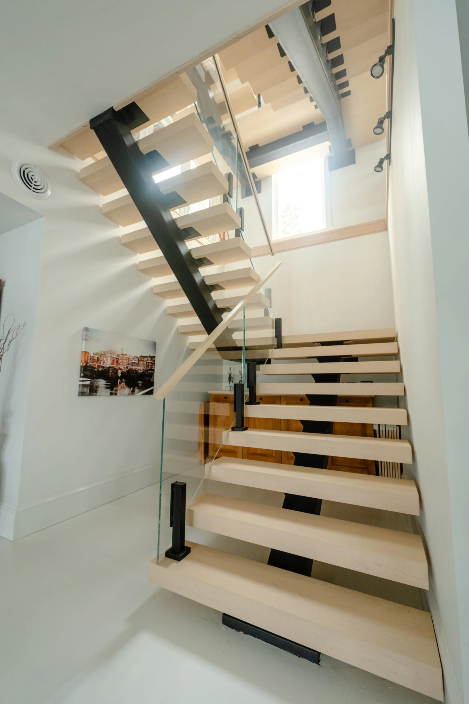 Angled view up the flight toward a skylight above the landing
