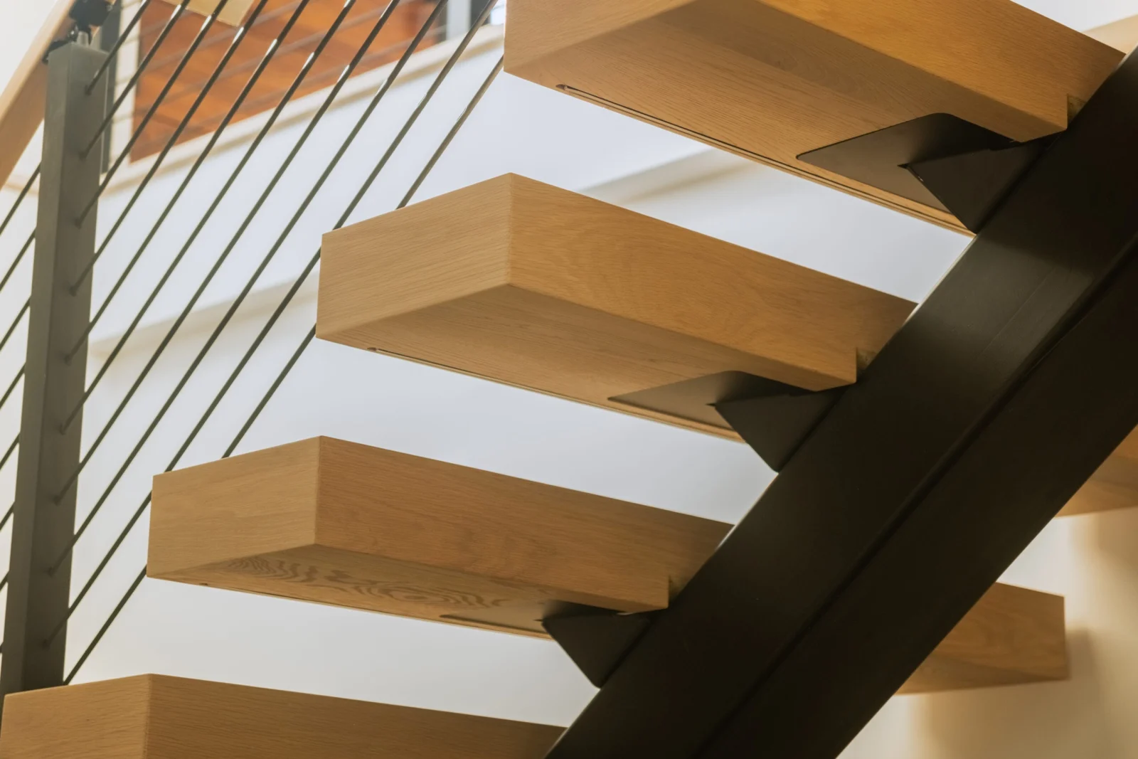 Close look at cantilevered treads meeting the dark steel stringer