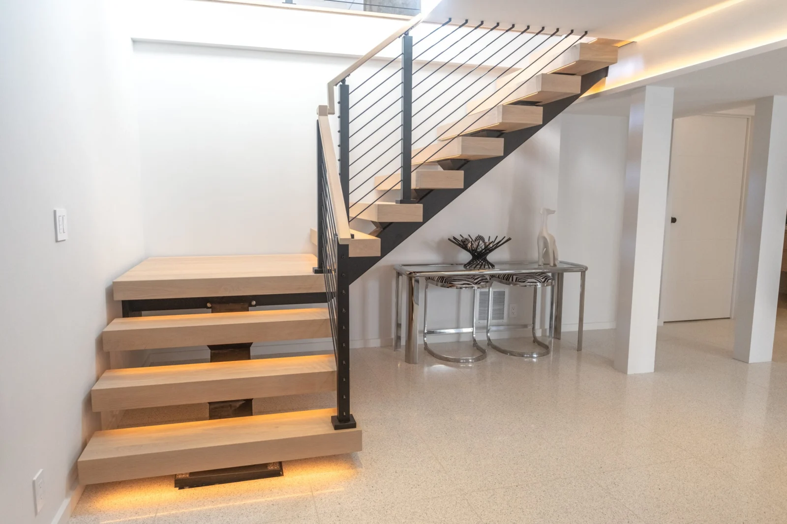 Side view of the stair's lower run and landing with rod infill railing
