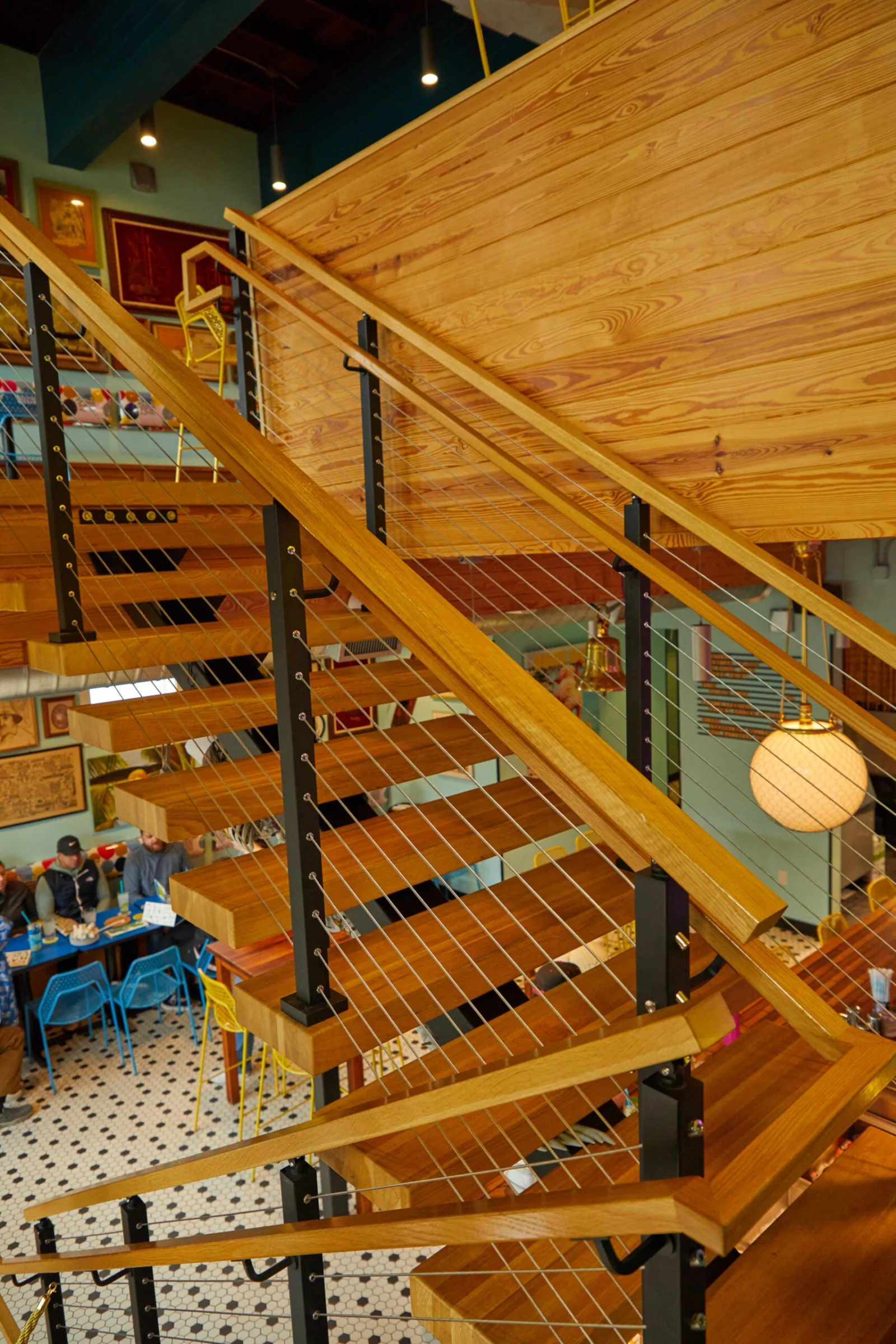 Looking down over the cable railing to the dining room from the upper level