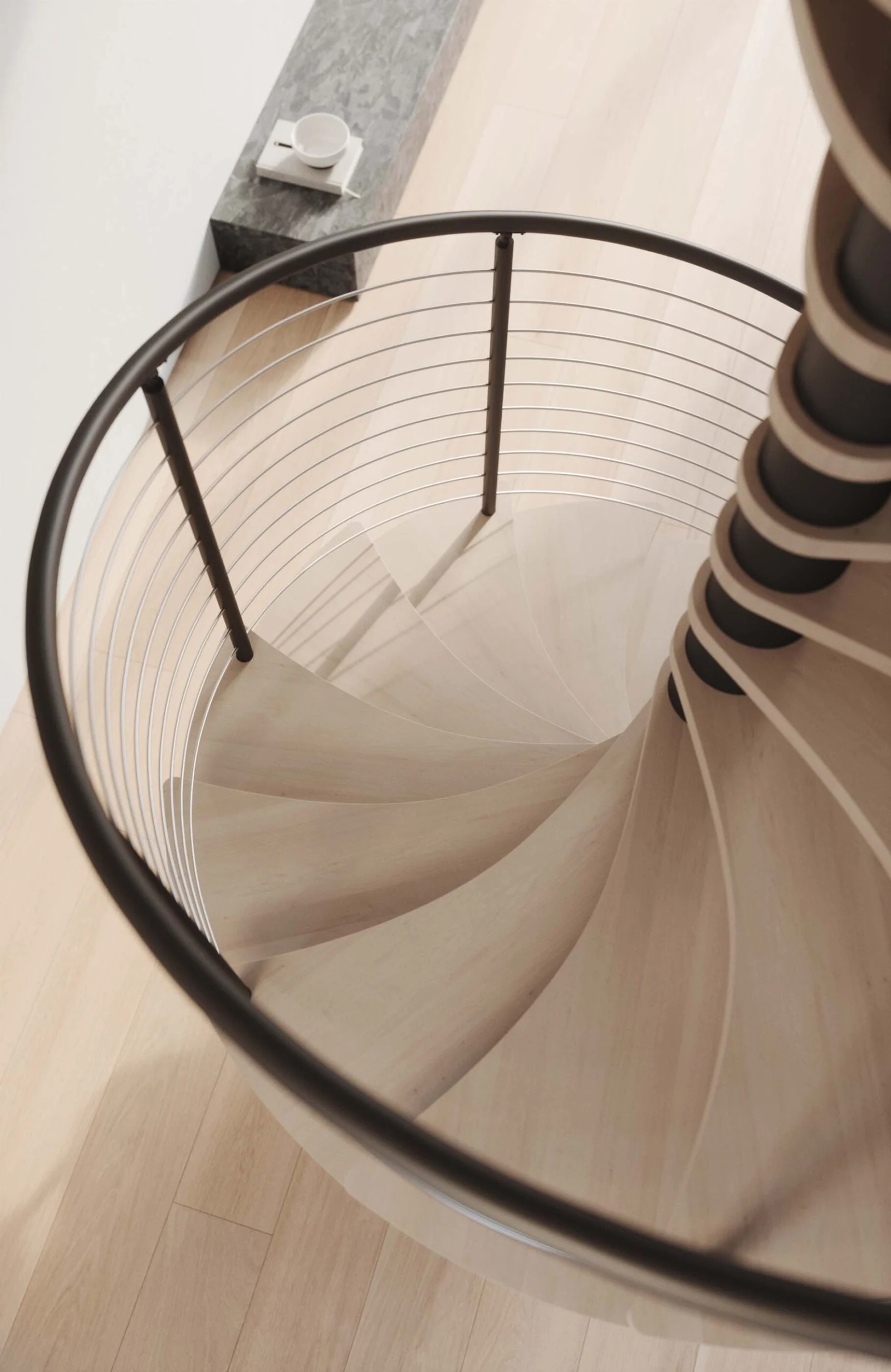 Looking straight down the spiral stair's overlapping pale treads and curved railing
