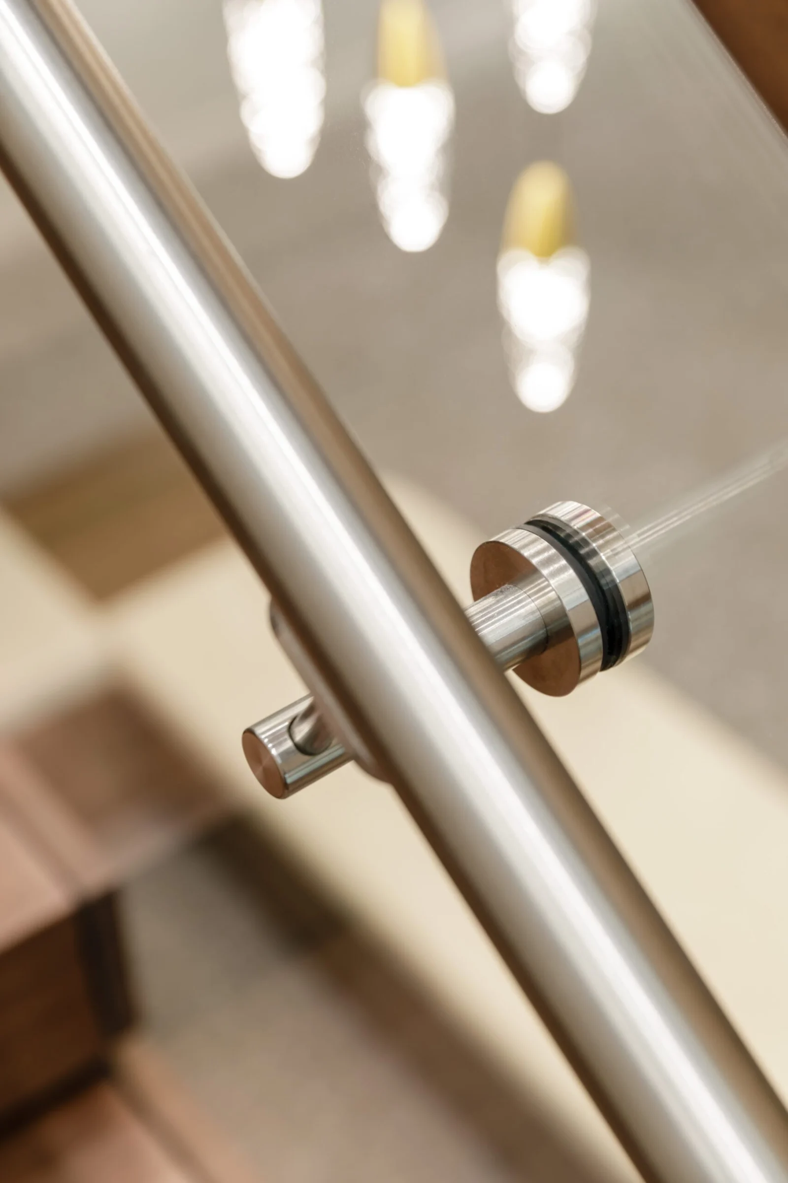 Angled close view of the stainless handrail and its round glass clamp