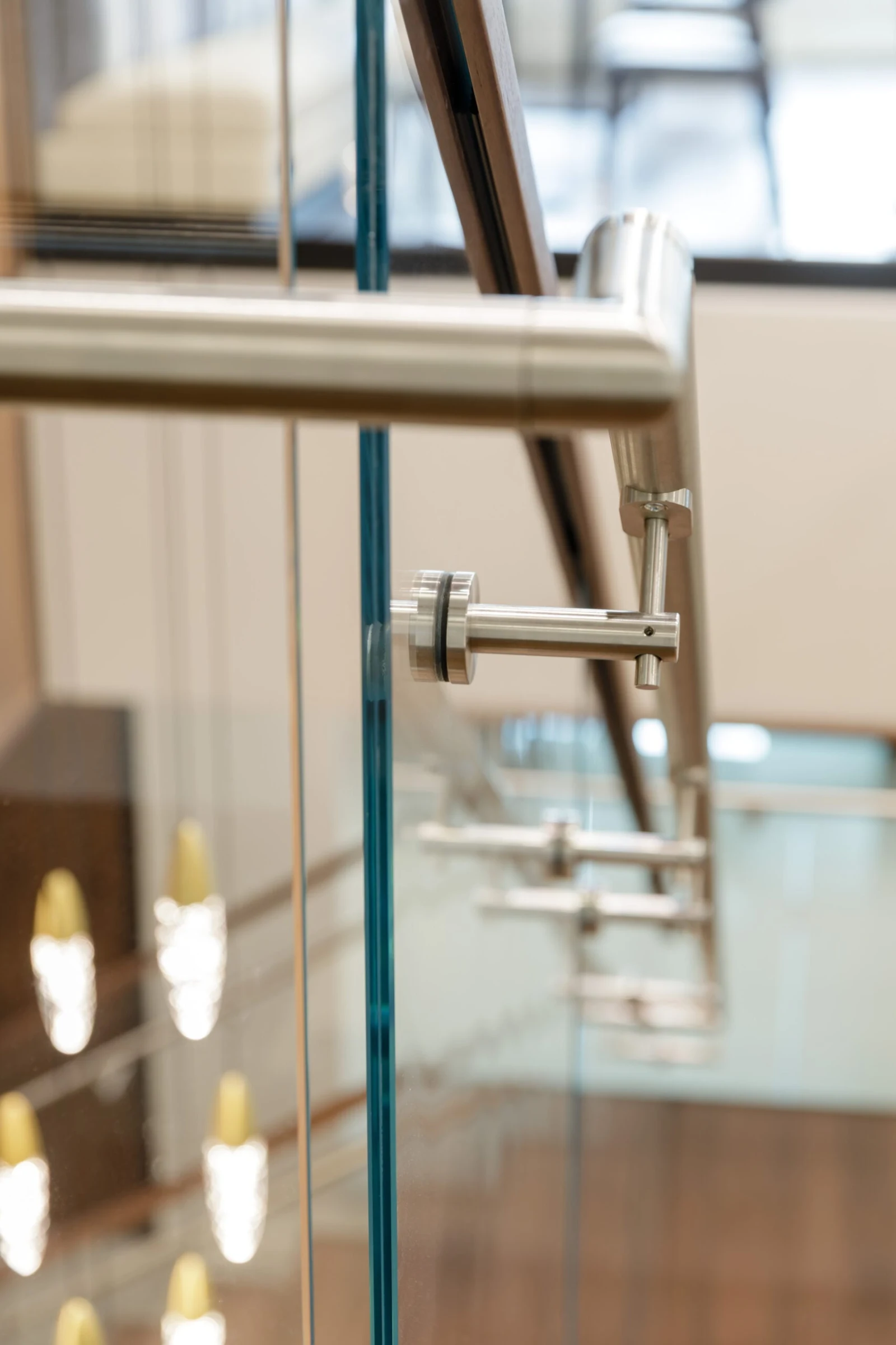 Handrail bracket seen through the glass panel with the flight falling away below