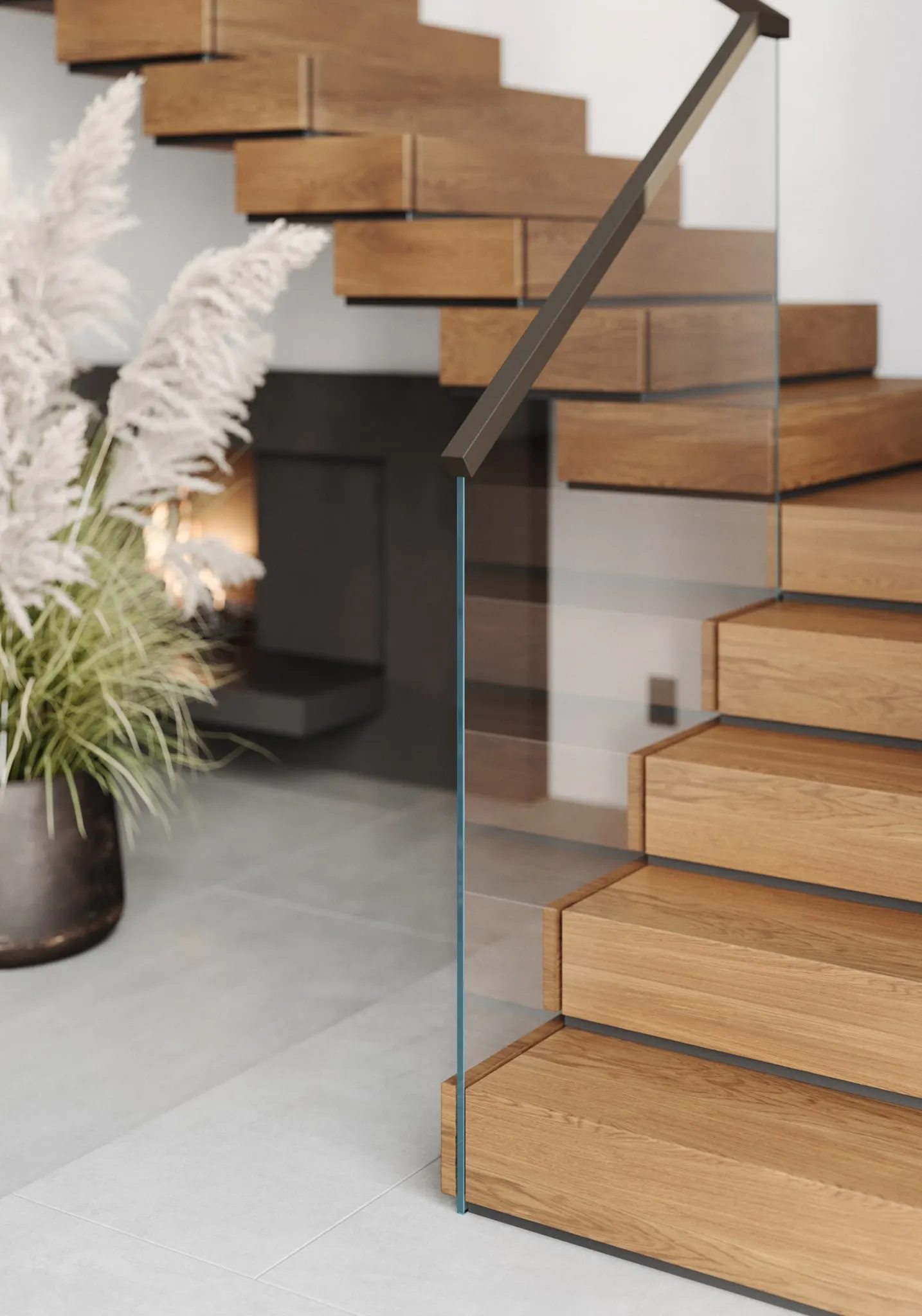 Stacked wood treads and glass railing beside a fireplace and dried grasses