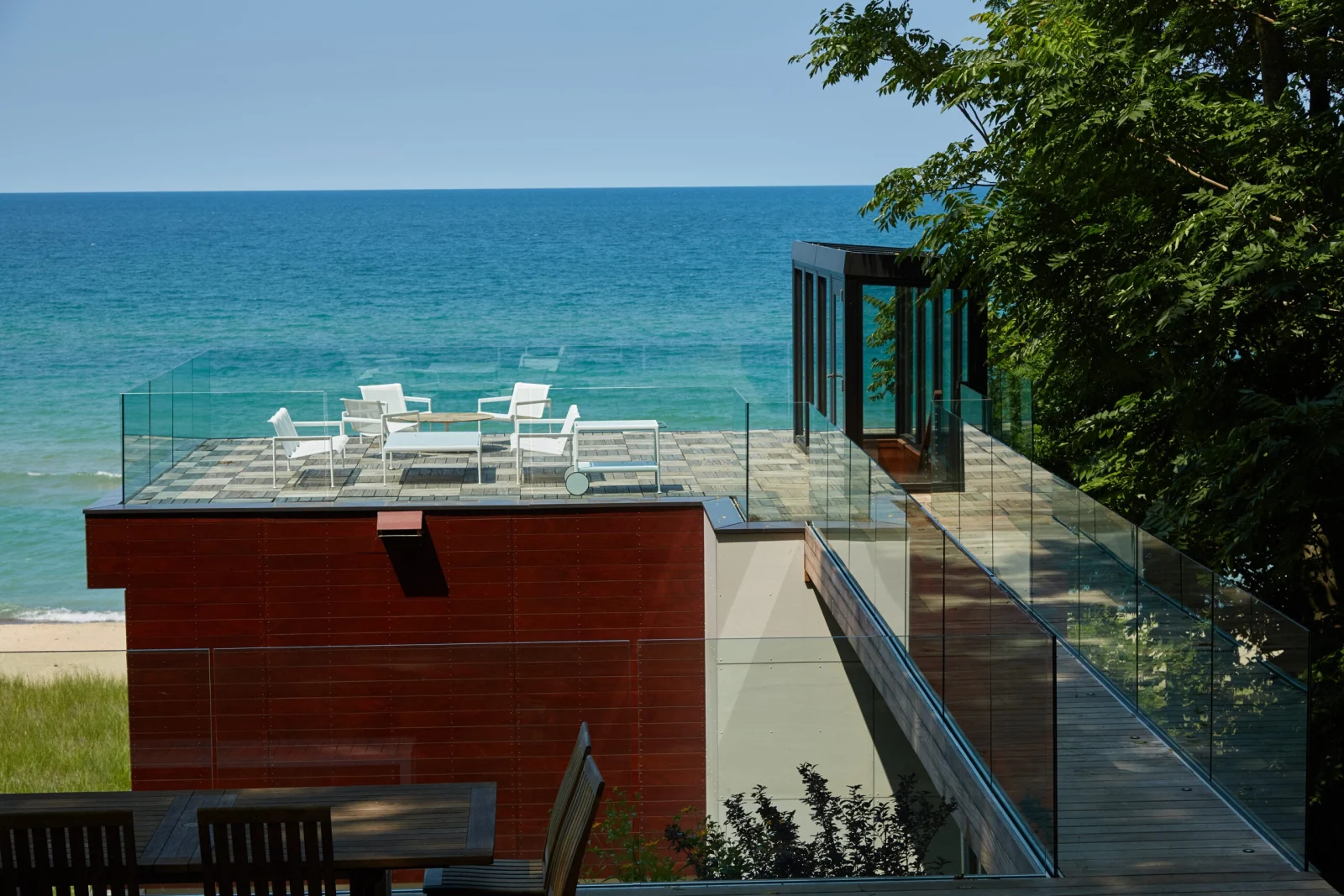Elevated deck and glass-railed bridge overlooking the shoreline and open water