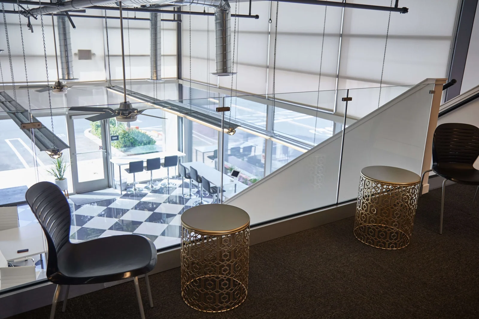 Mezzanine seating looking down over glass railing to the checkerboard floor below