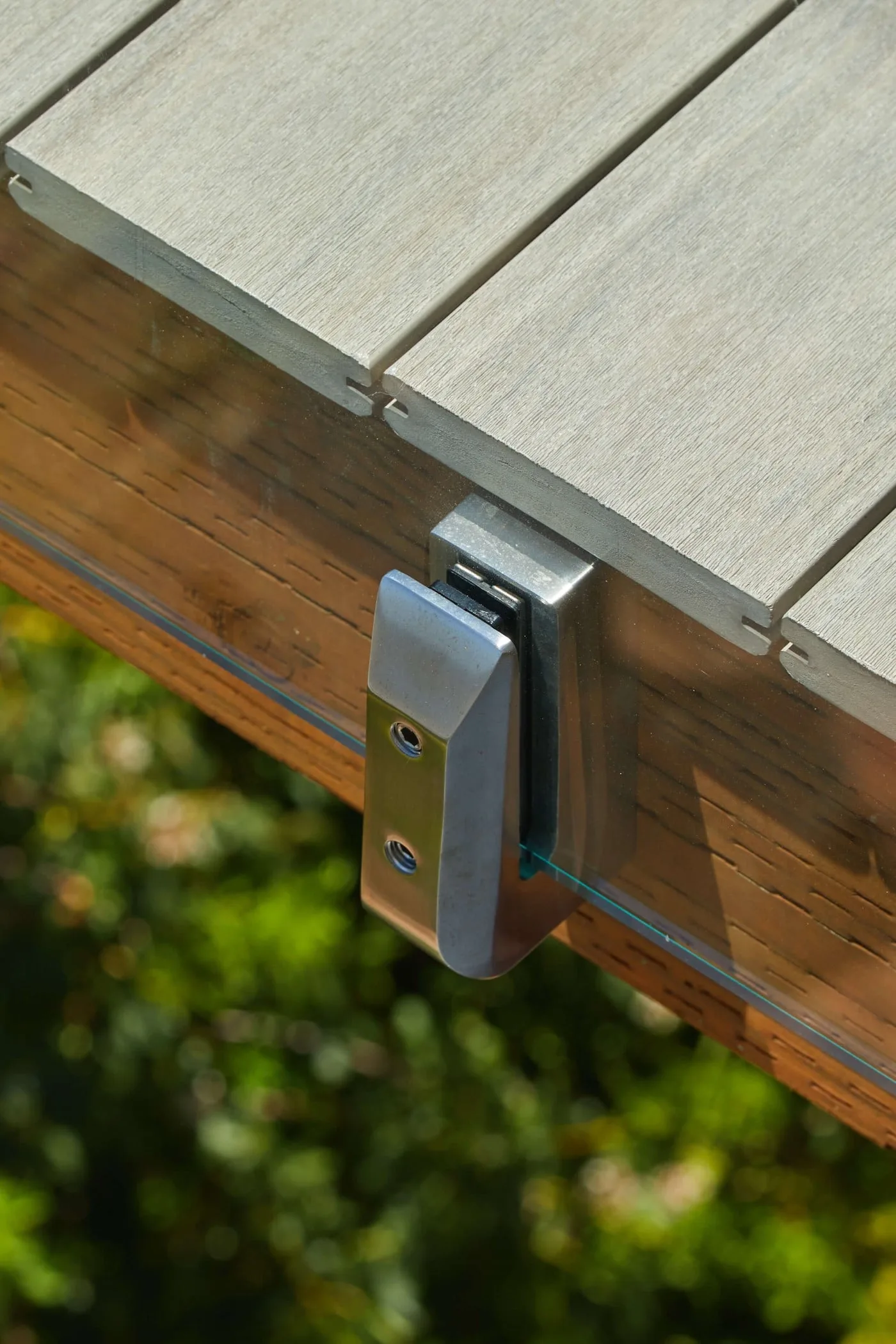 Stainless side-mount spigot bolted to the rim joist below composite decking