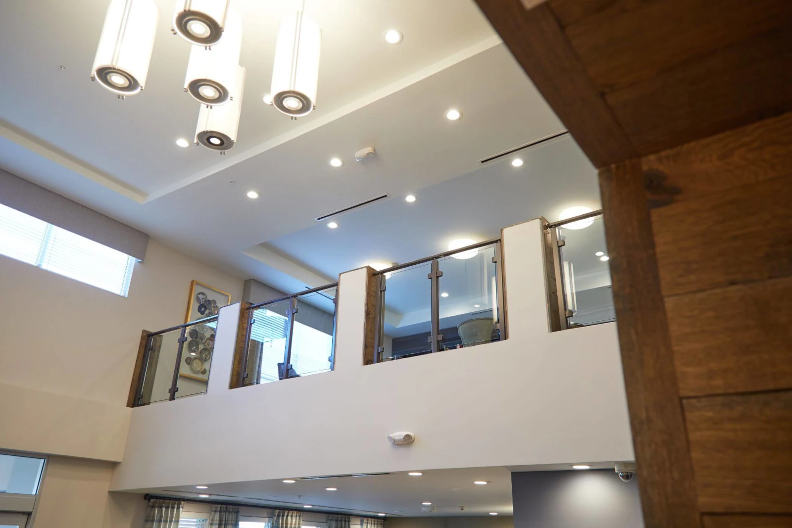 Timber beam in the foreground framing the balcony railing along the upper level