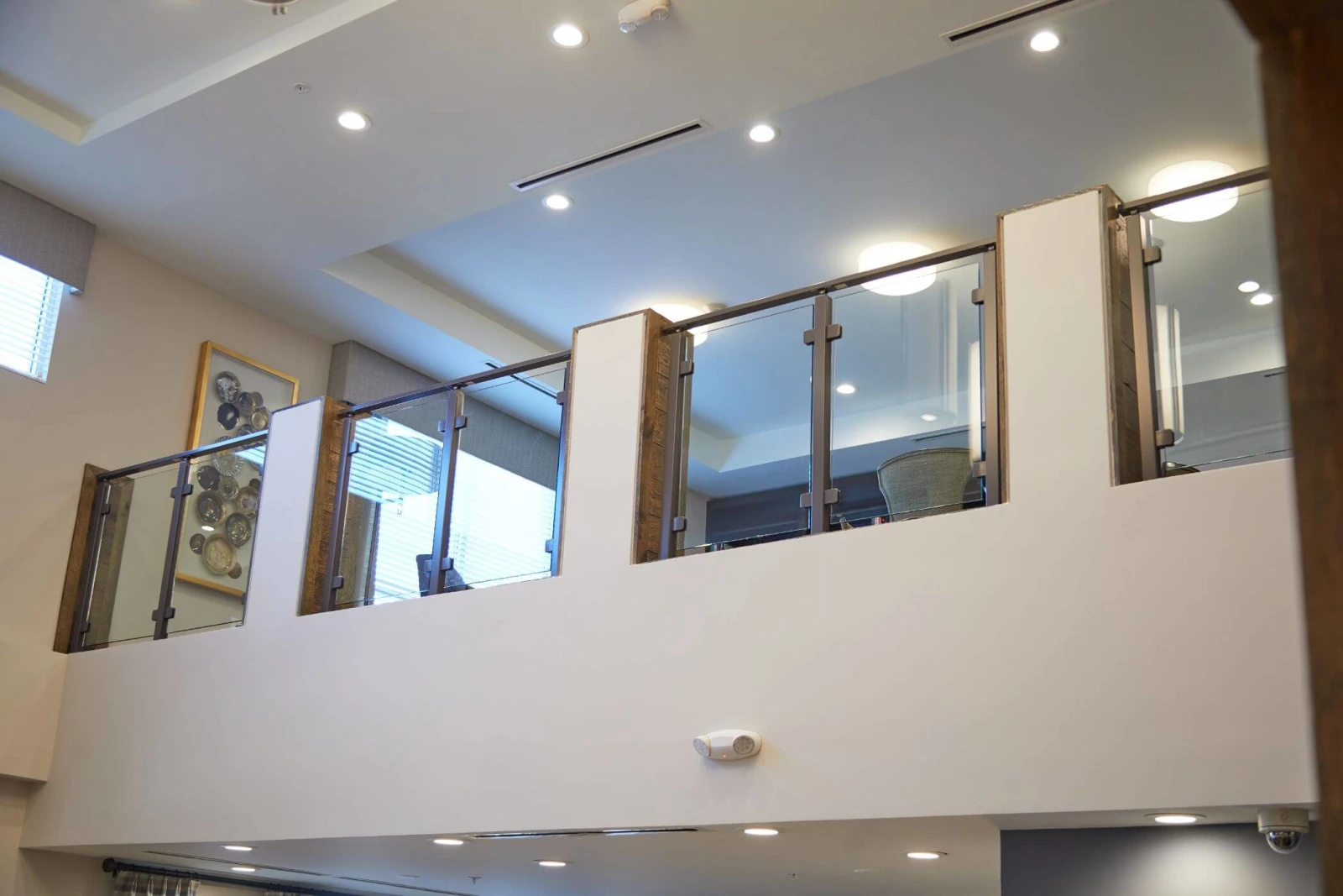 Mezzanine railing seen from the lobby below against a recessed lit ceiling