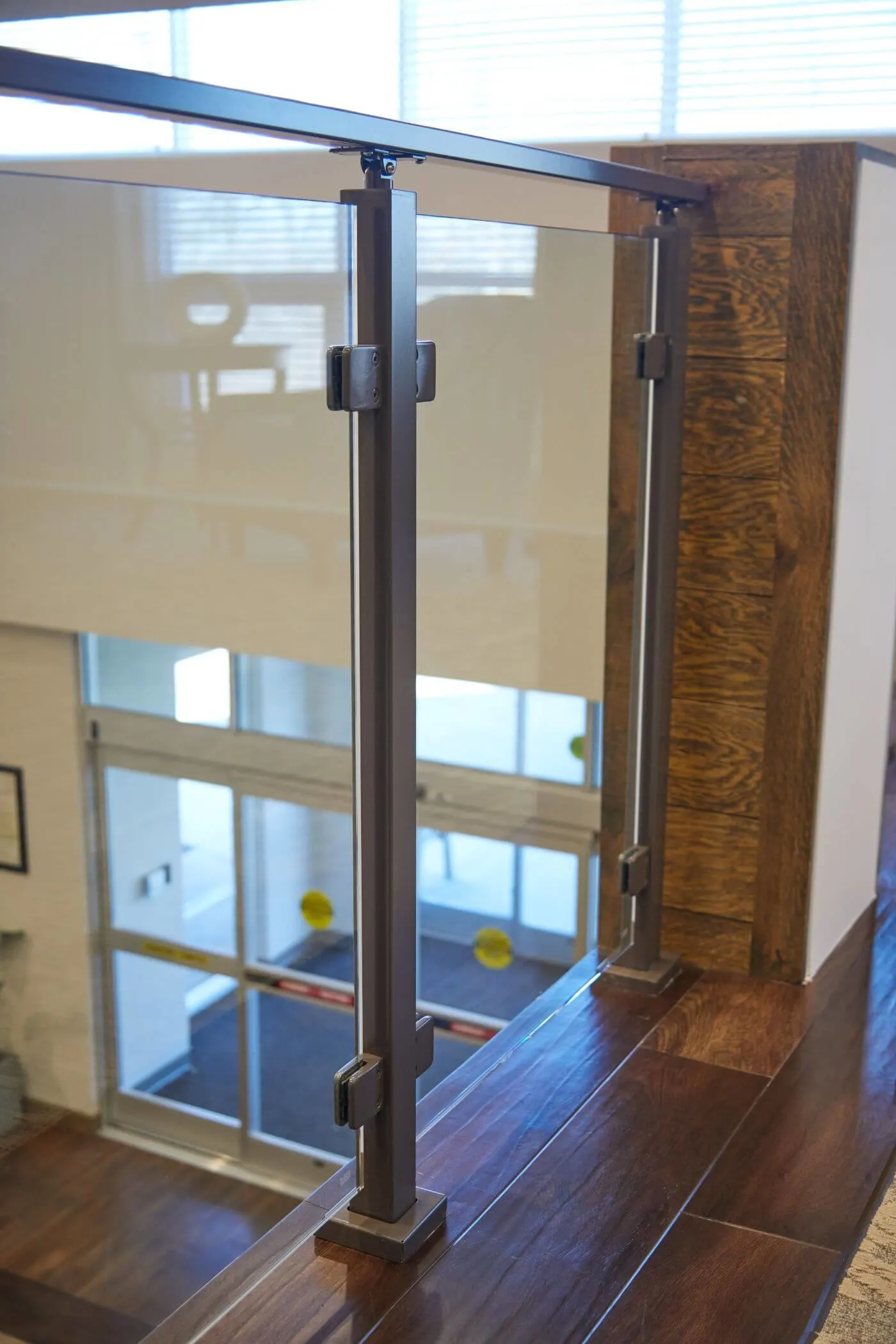 Single glass panel and post guarding an opening that overlooks the floor below