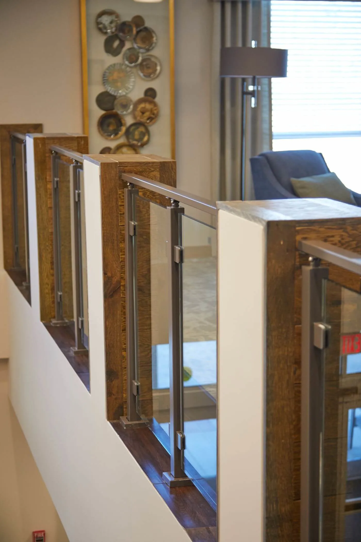 Bronze posts and glass panels lining an open balcony above a lounge