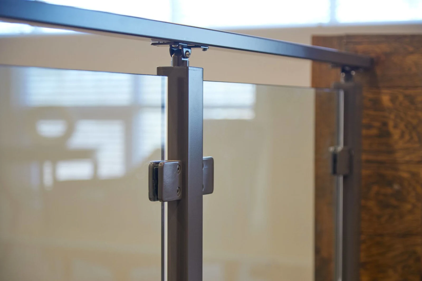 Post top meeting the rail where two glass panels are clamped together