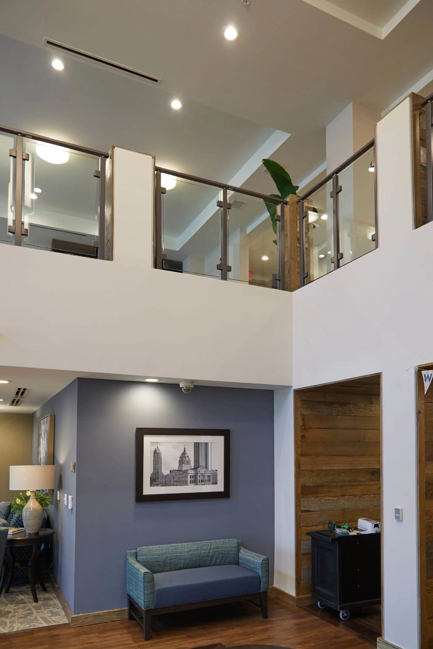 Upper-level railing seen across a tall atrium above a sitting area