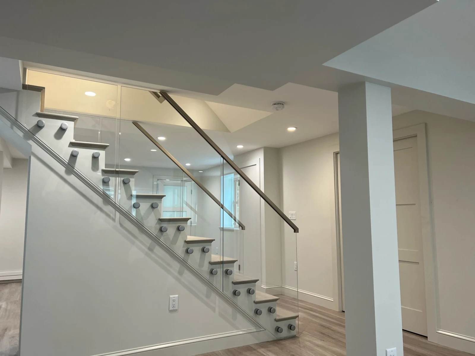 Full stair seen from the room with glass guarding it on standoff pins