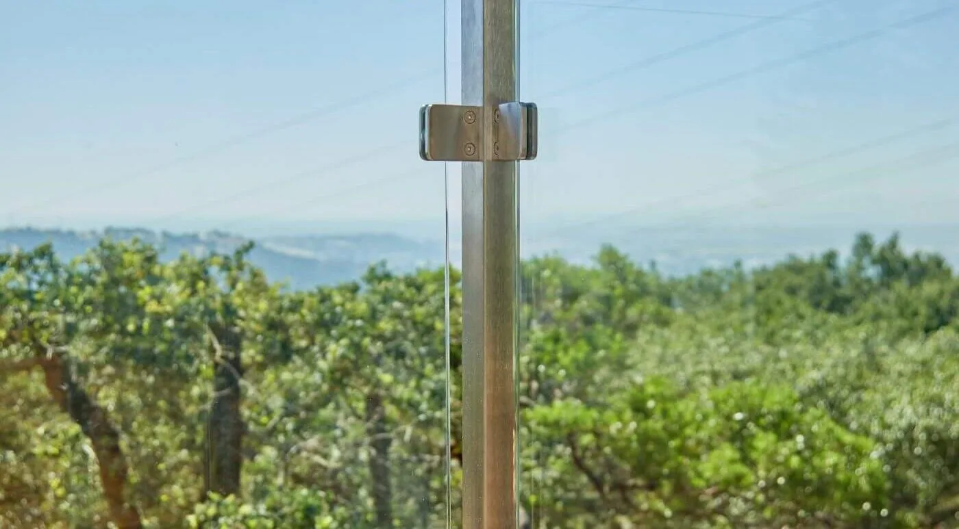 Single post and clamp centered against an out-of-focus hillside of trees
