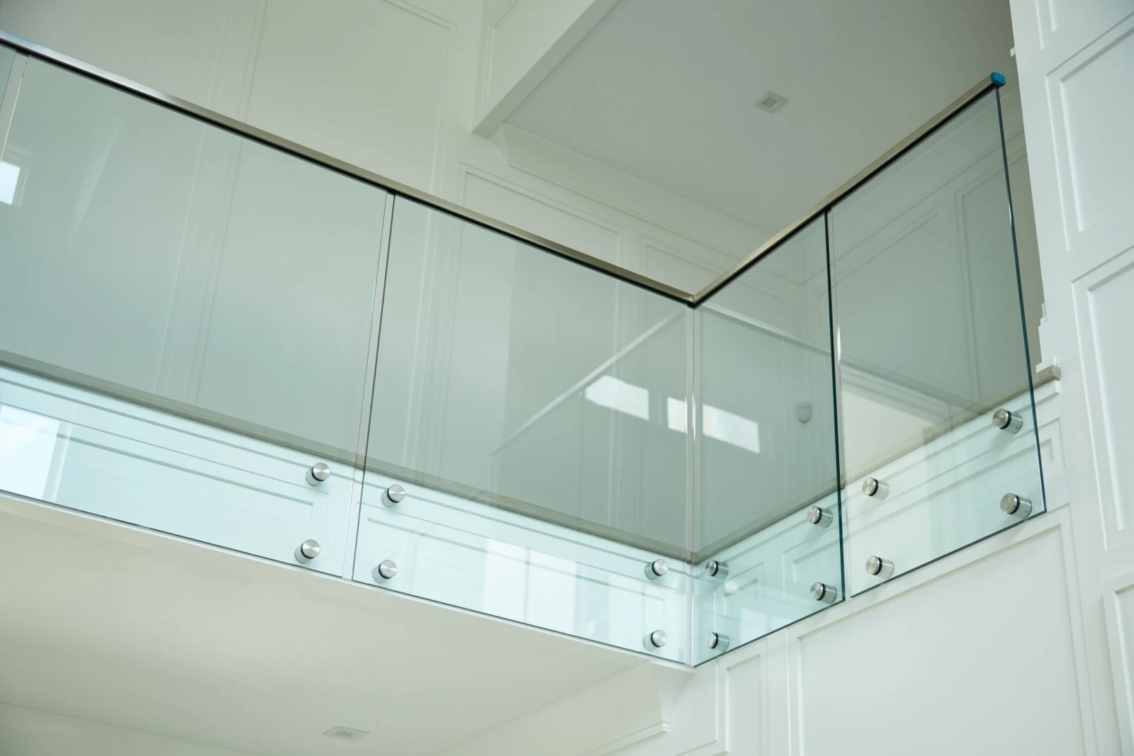 Glass railing turning an inside corner seen from the floor below