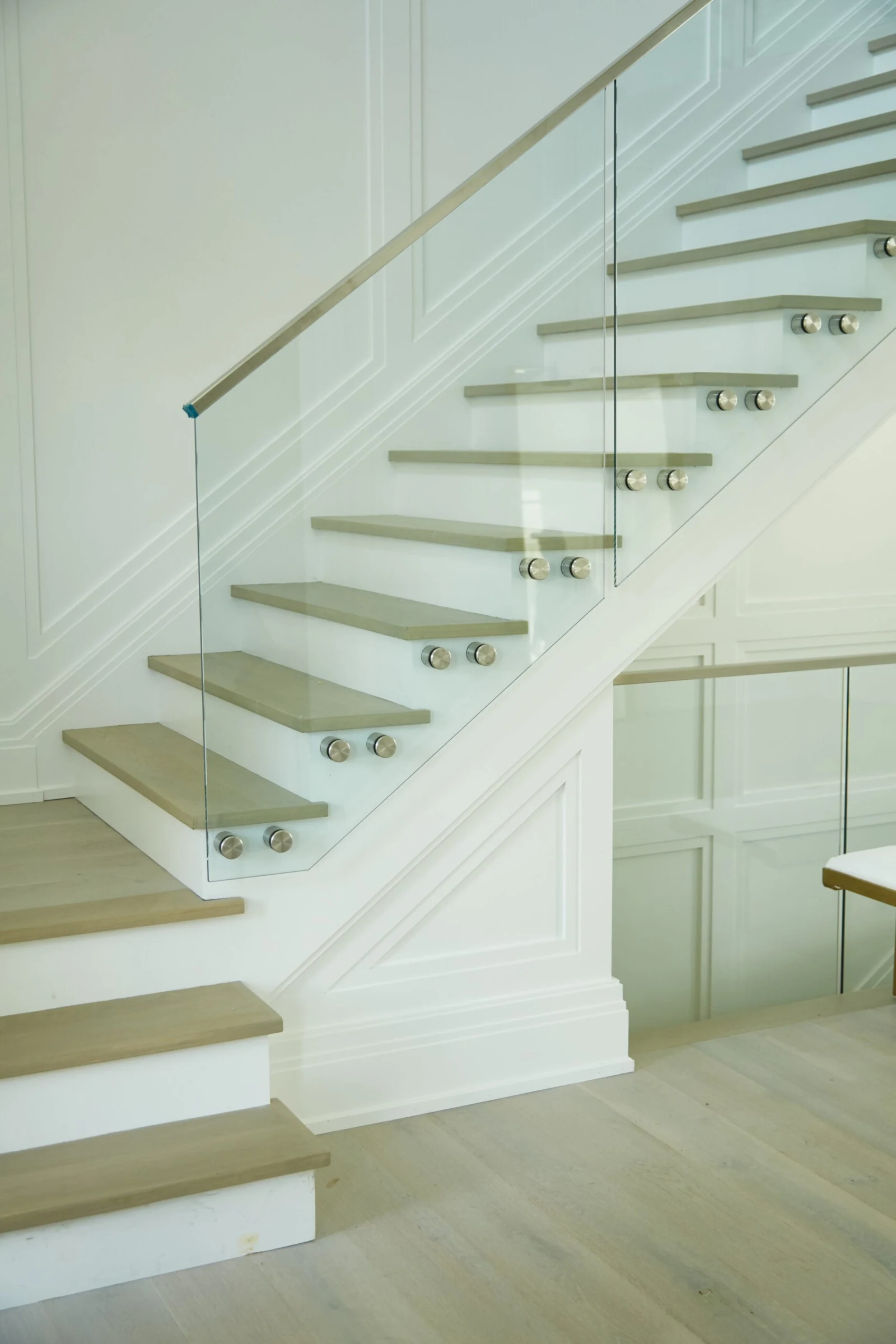 Open-riser flight with wood treads set behind a single sheet of glass