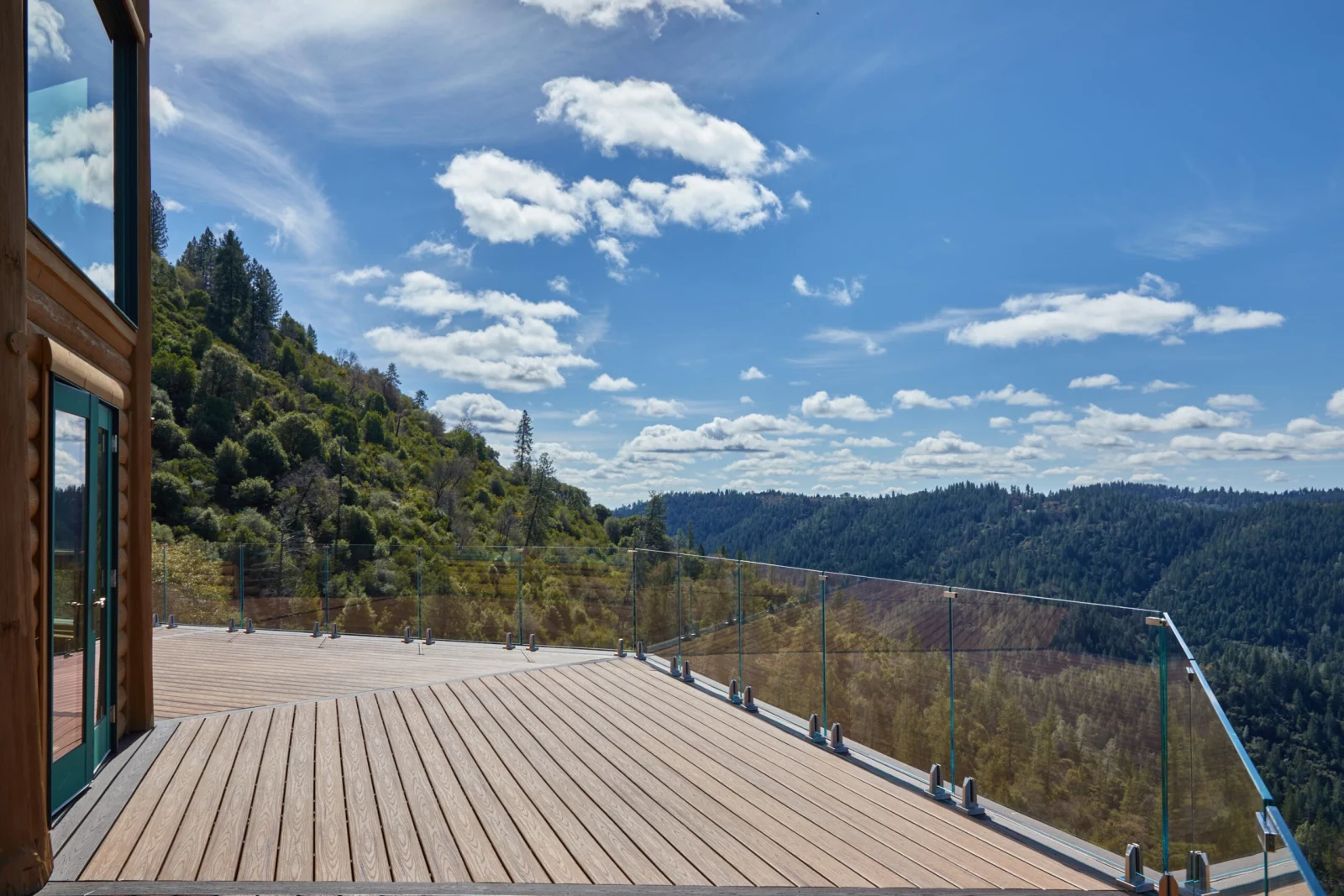 Wide deck viewed from the doorway with glass railing keeping the view open