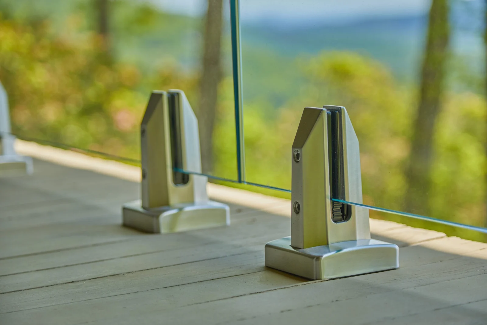 Two polished base clamps in sharp focus with the mountains blurred beyond