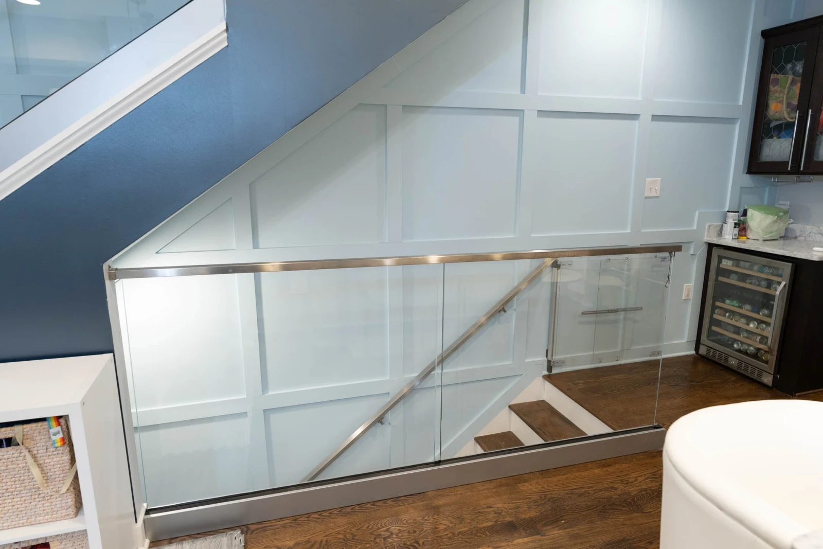 Glass panels in a metal base channel with stainless top rail enclosing a basement stair