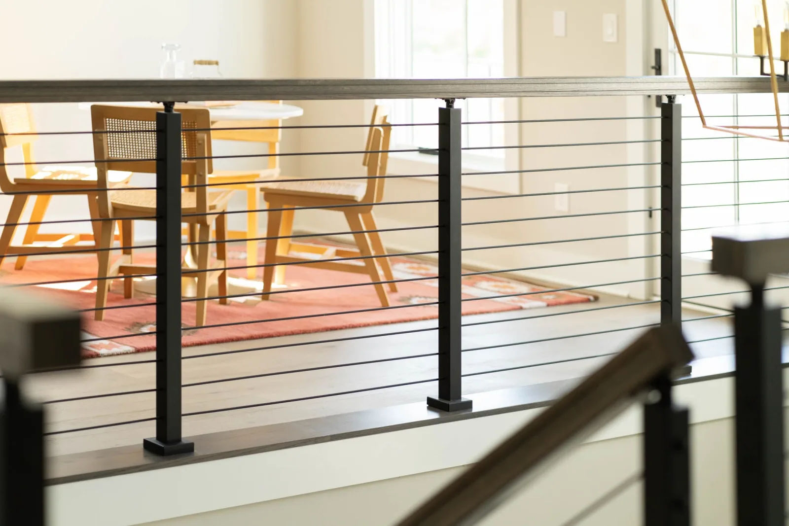Balcony rods and posts screening a dining table and chairs on a rug
