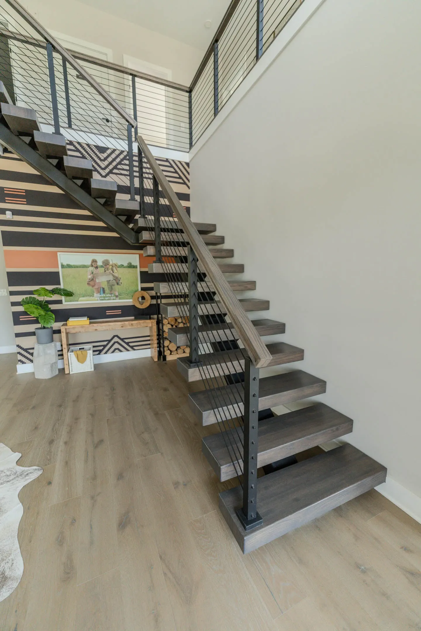 Straight flight on a black center stringer with gray treads and rod railing