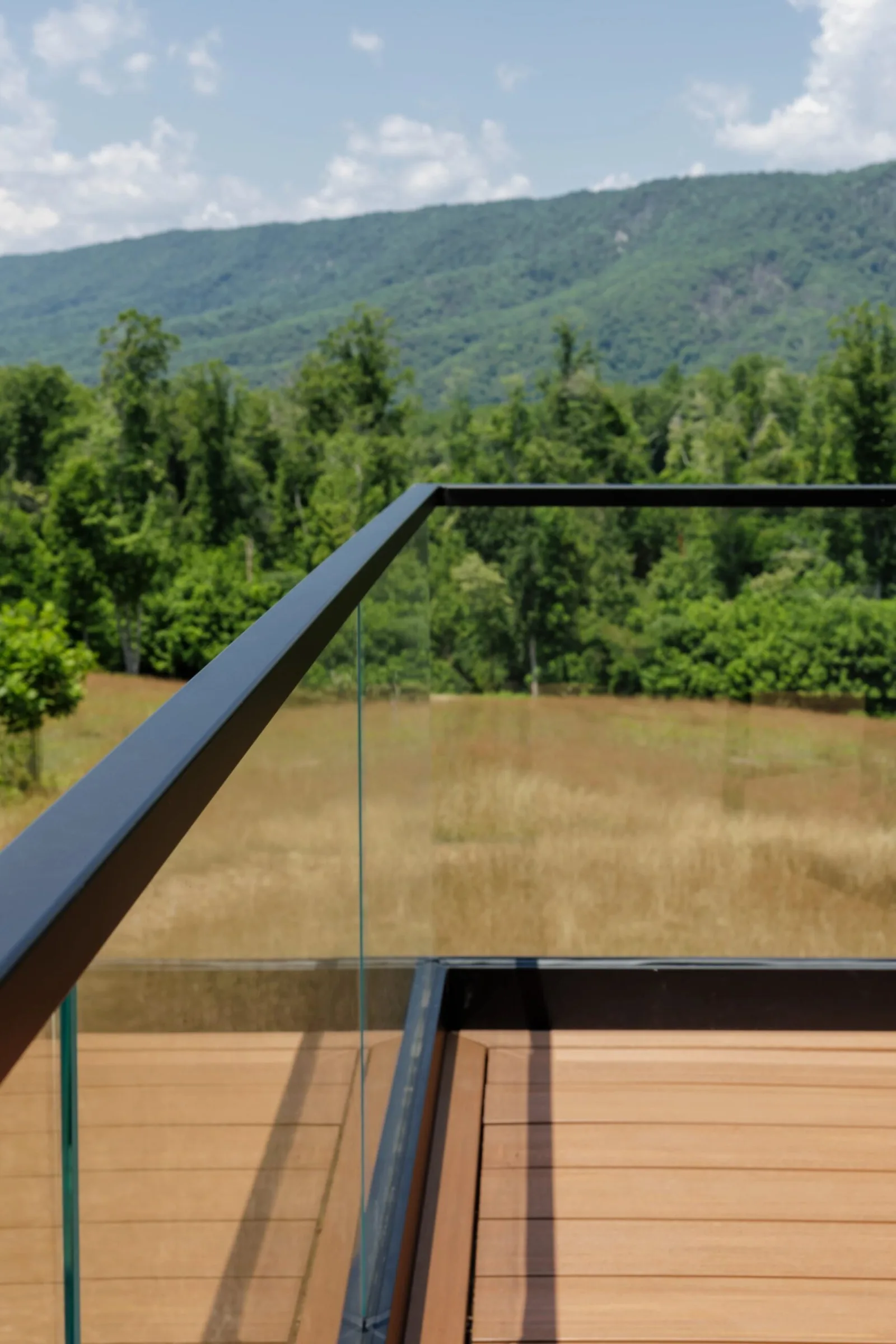 Corner of the deck where a dark cap rail turns above clear glass panels