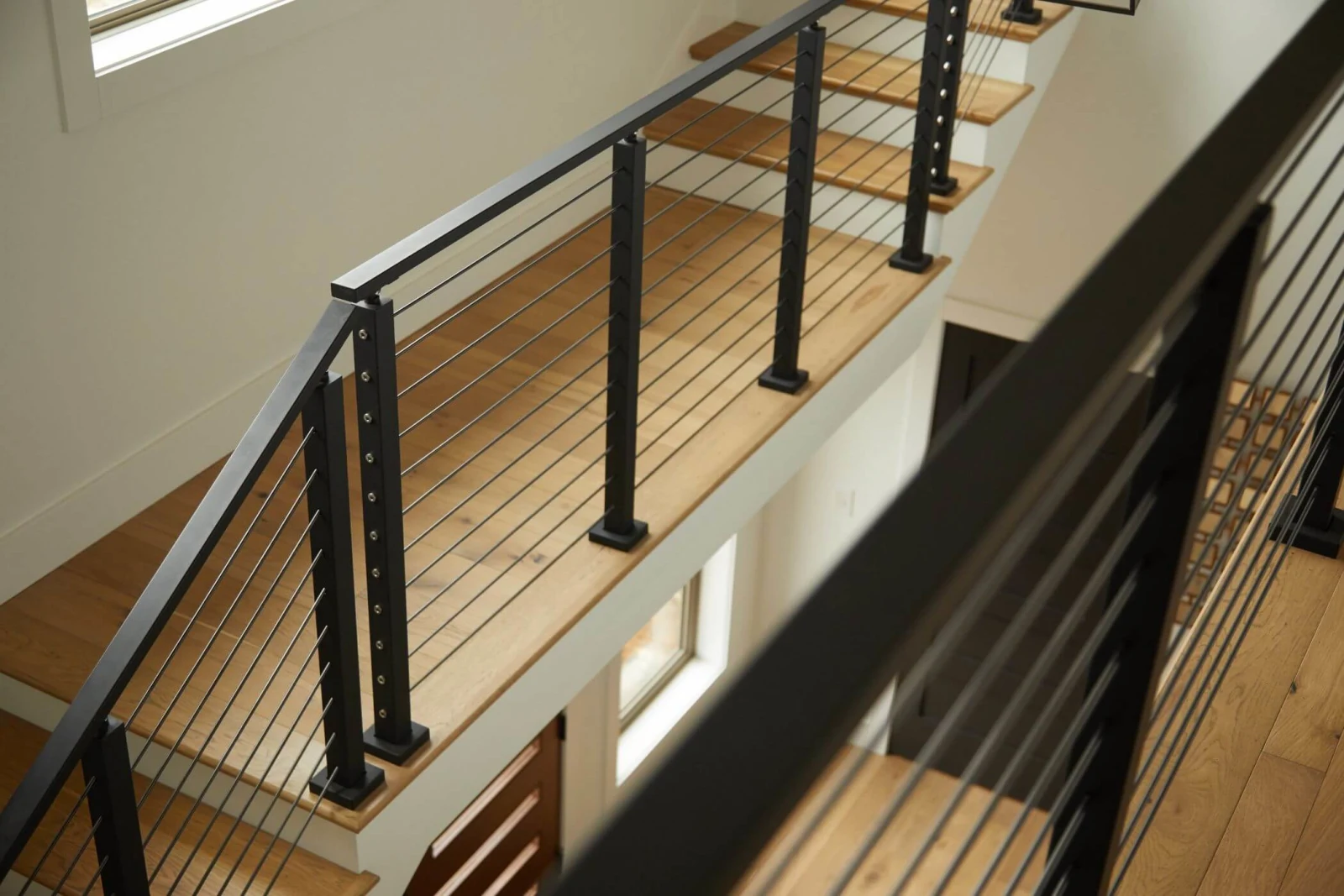 Downward view of the railing wrapping the landing and stair opening