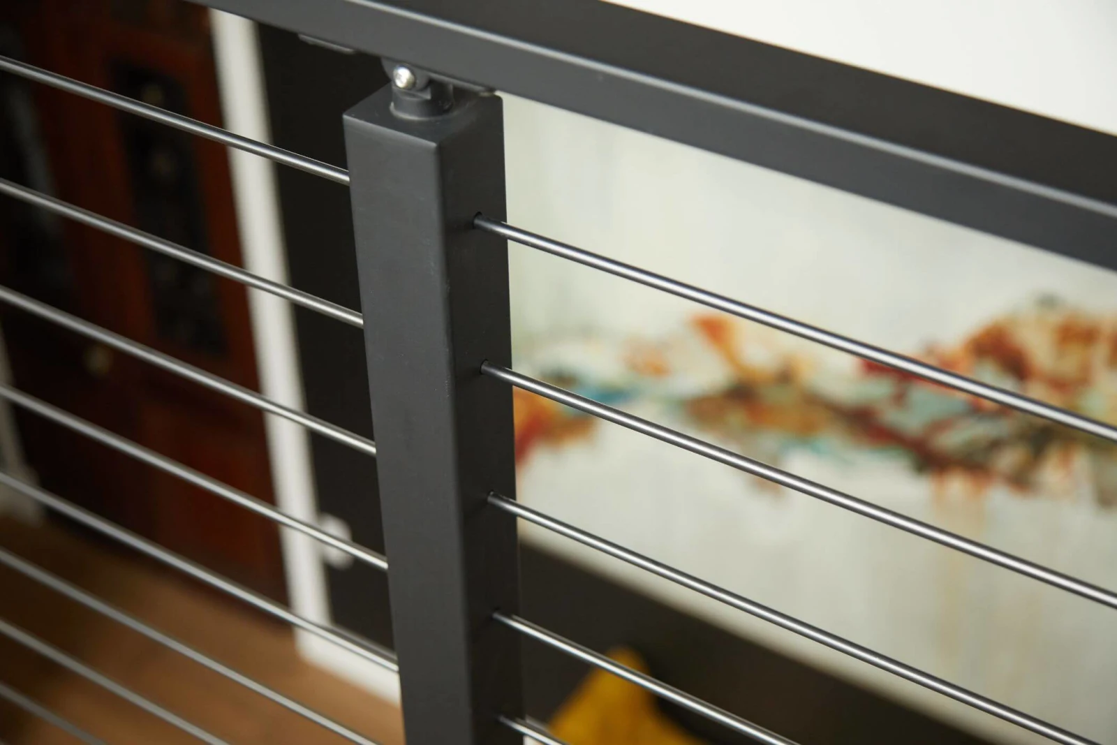 Close view of rods seated in a black post with artwork blurred behind