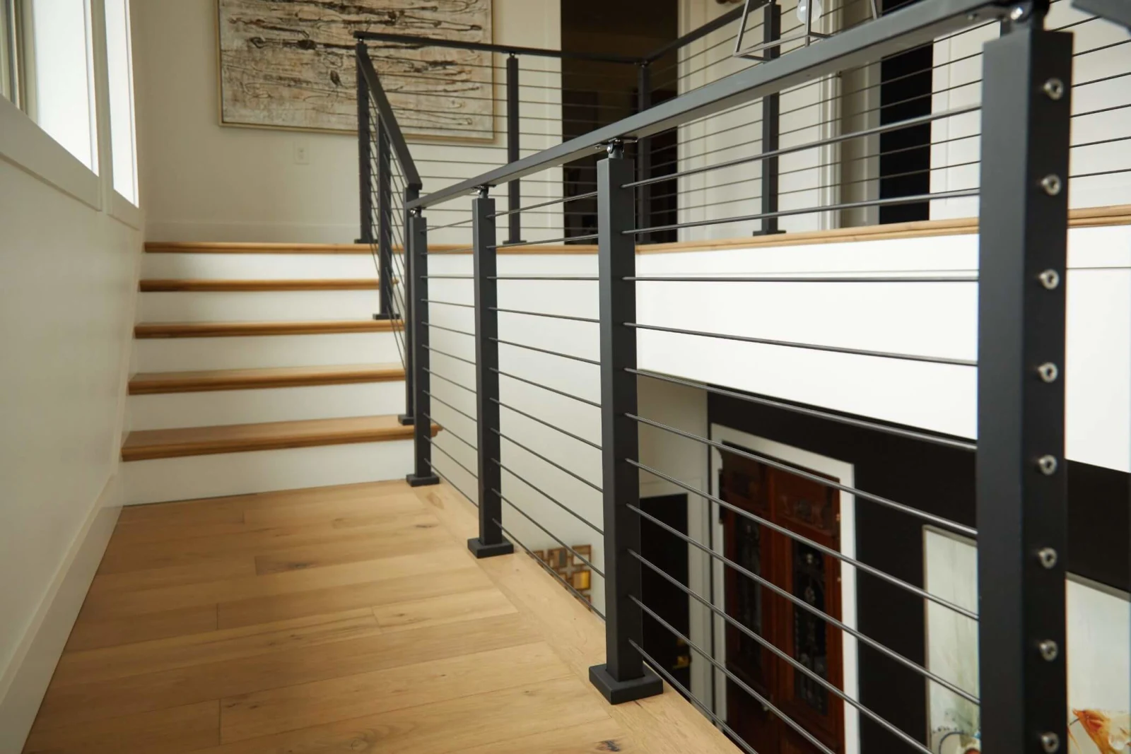 Stair and landing rails above a slatted wood door in the entry