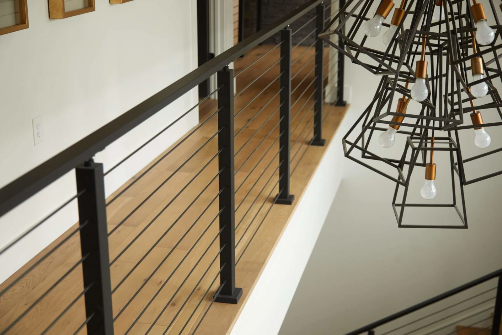 Angled view along the rods with a large caged chandelier filling the frame