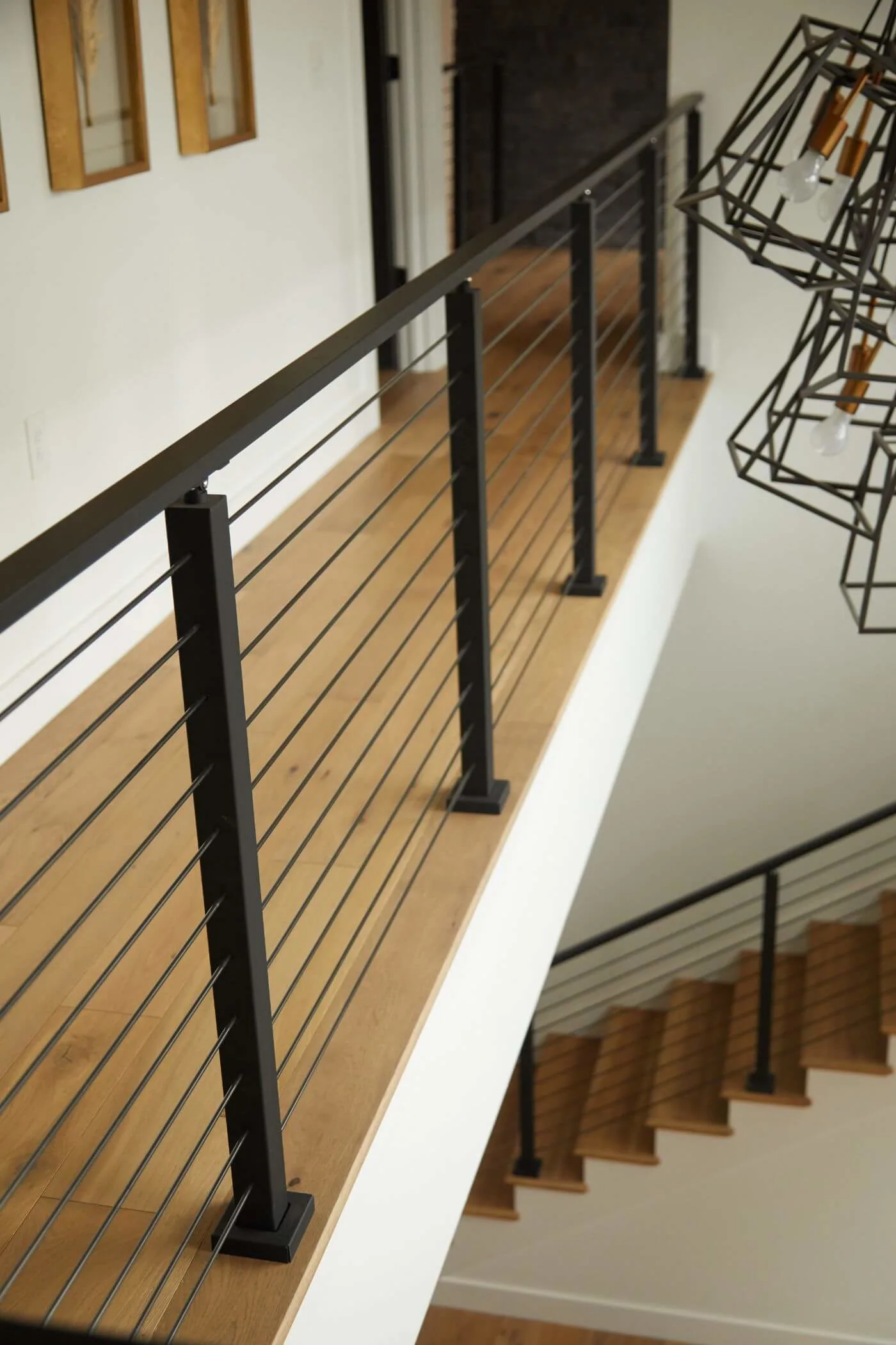Balcony railing sweeping past a black geometric fixture toward the flight