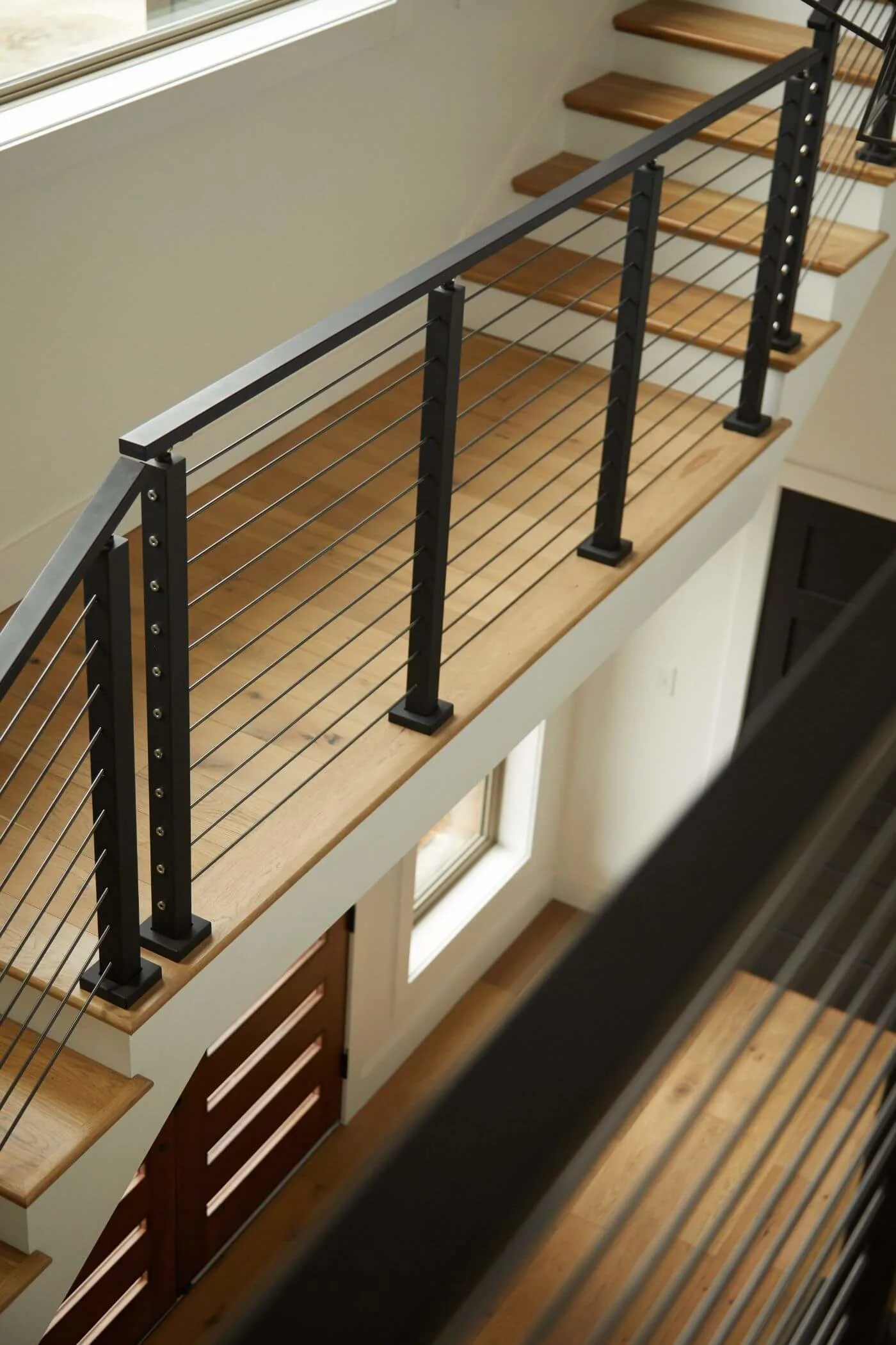 Looking over the balcony rods toward a narrow window below