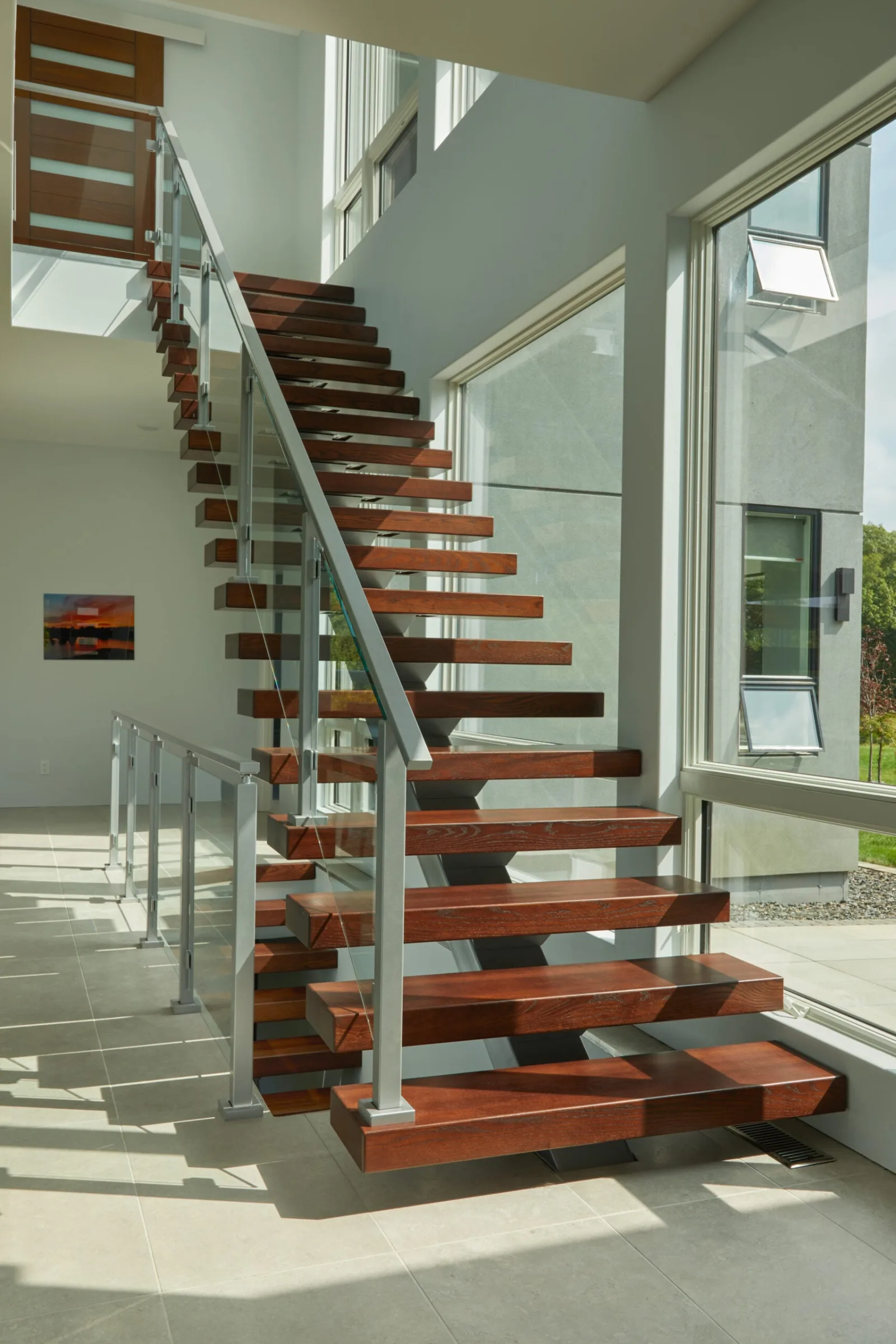 Full side view of the stair turning at the bottom onto a tiled floor