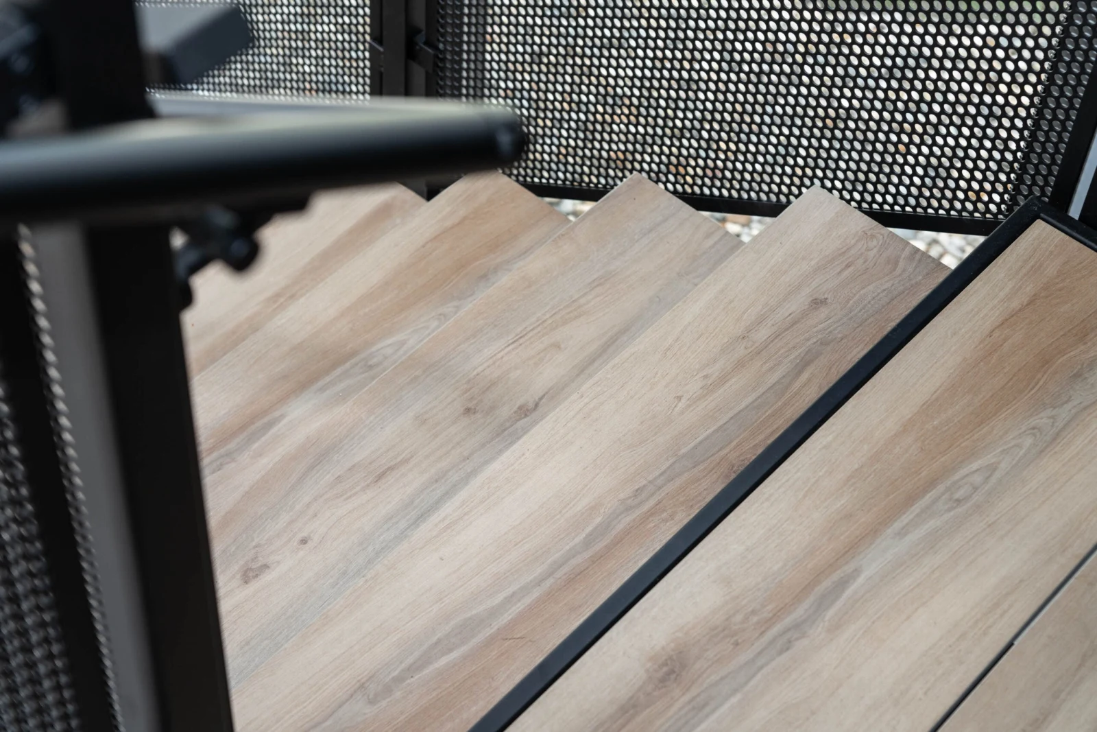 Overhead close-up of light wood-look porcelain treads with black nosings