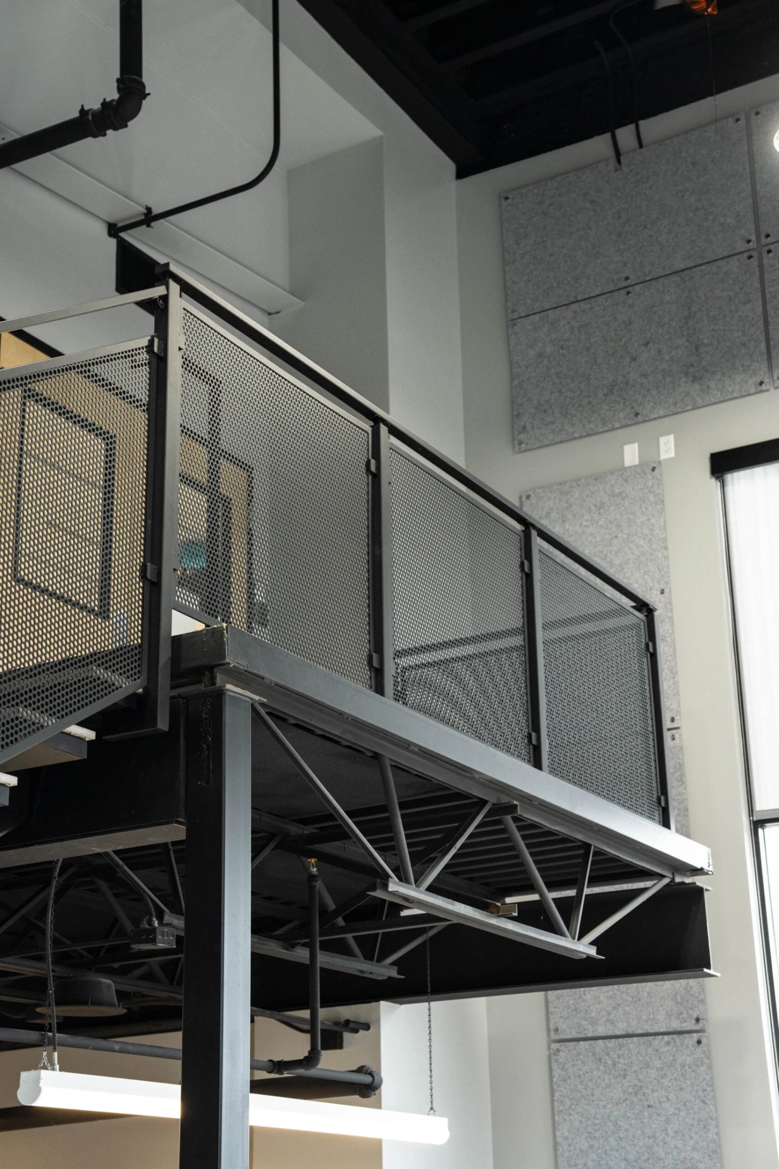 Underside of the steel landing showing truss framing and the railing above