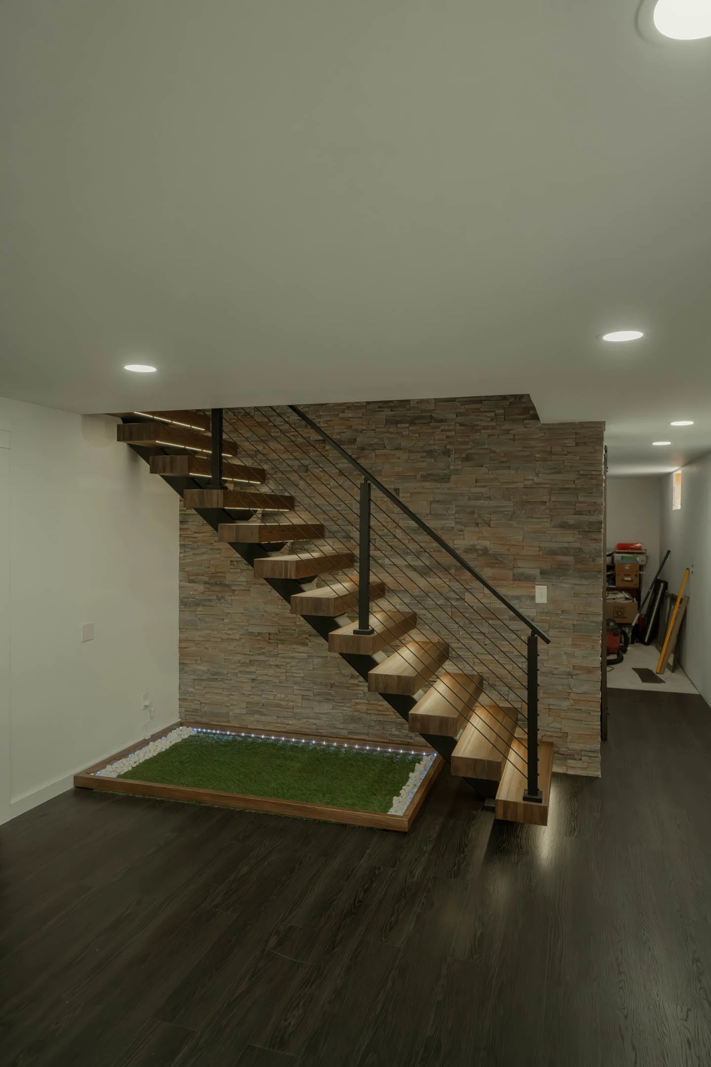 After: a floating stair with rod railing lands on a finished lower level