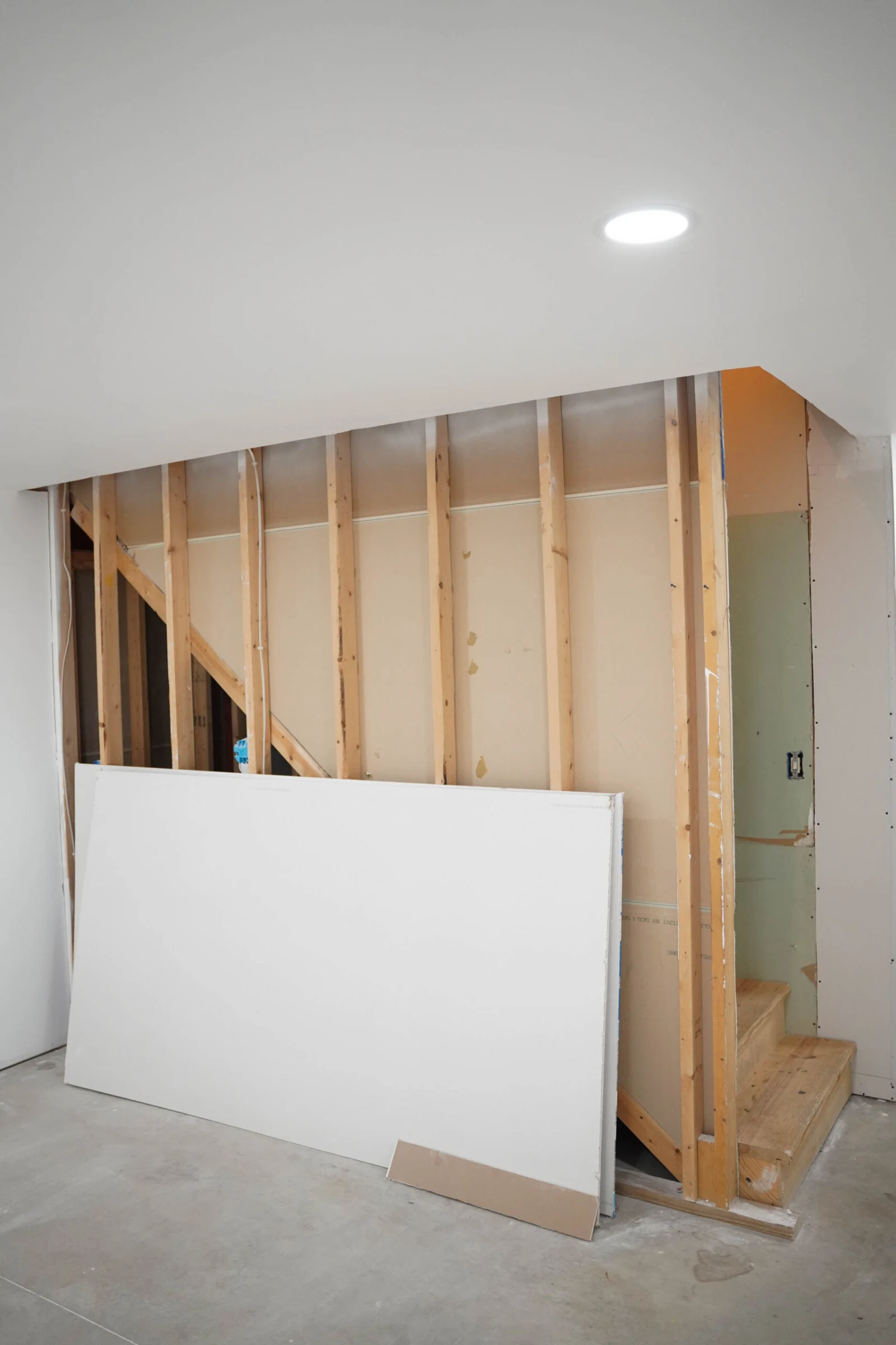 Before: bare framing and an unfinished stair in the same lower level