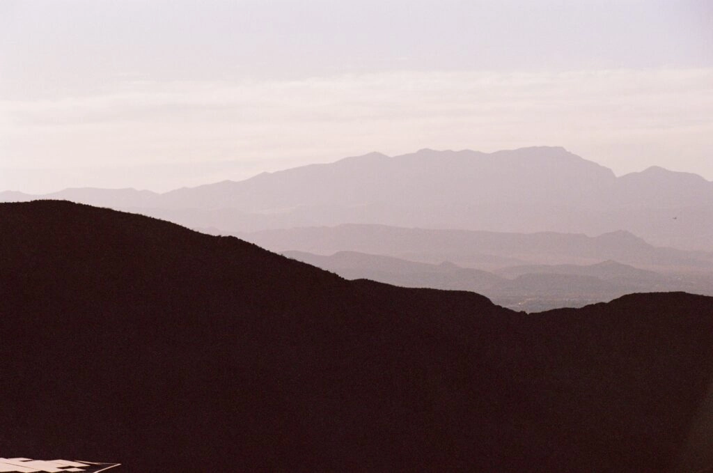 Layered desert ridges fade into haze toward the end of the day
