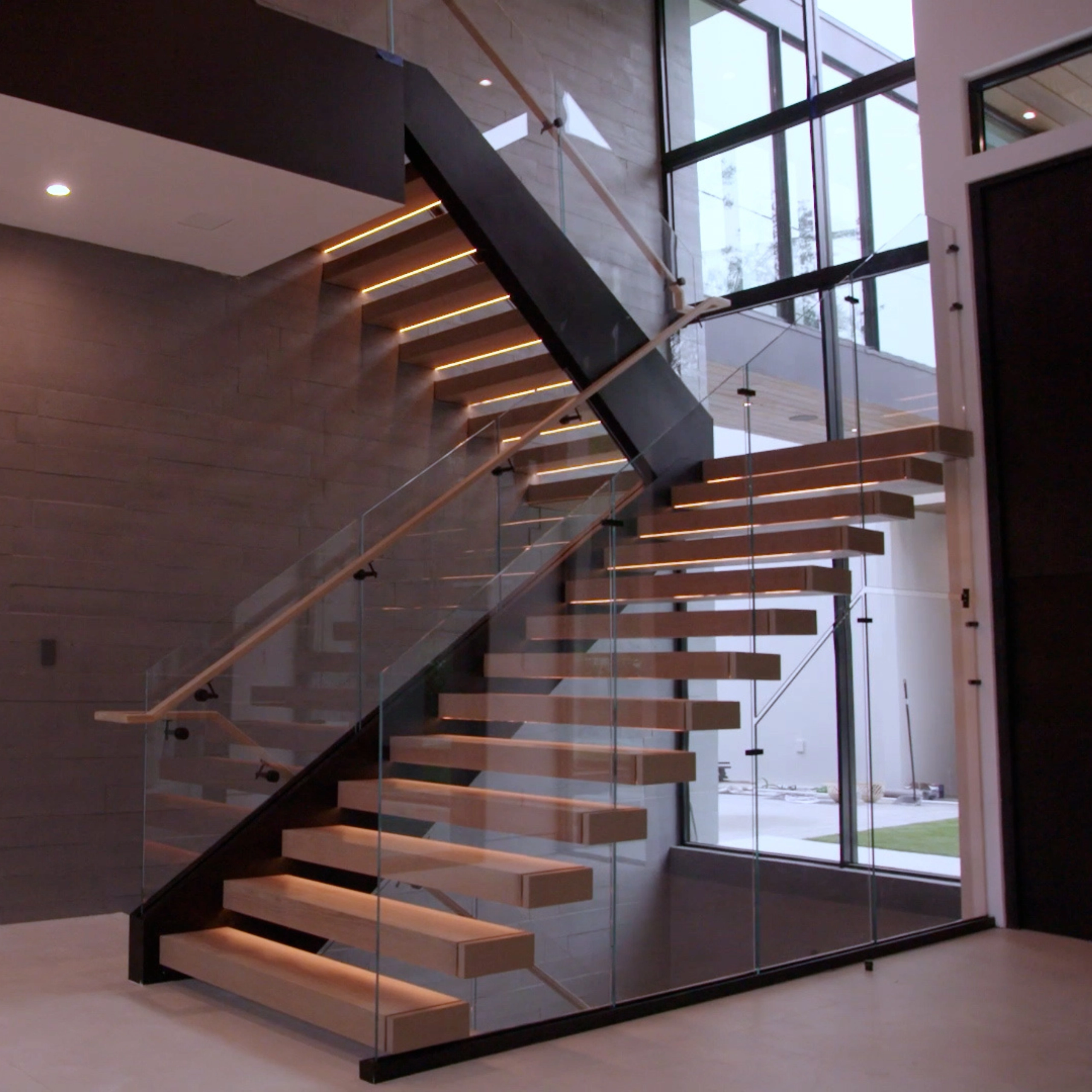 FLIGHT Blade rises along a dark wood wall with glass railing and wide windows