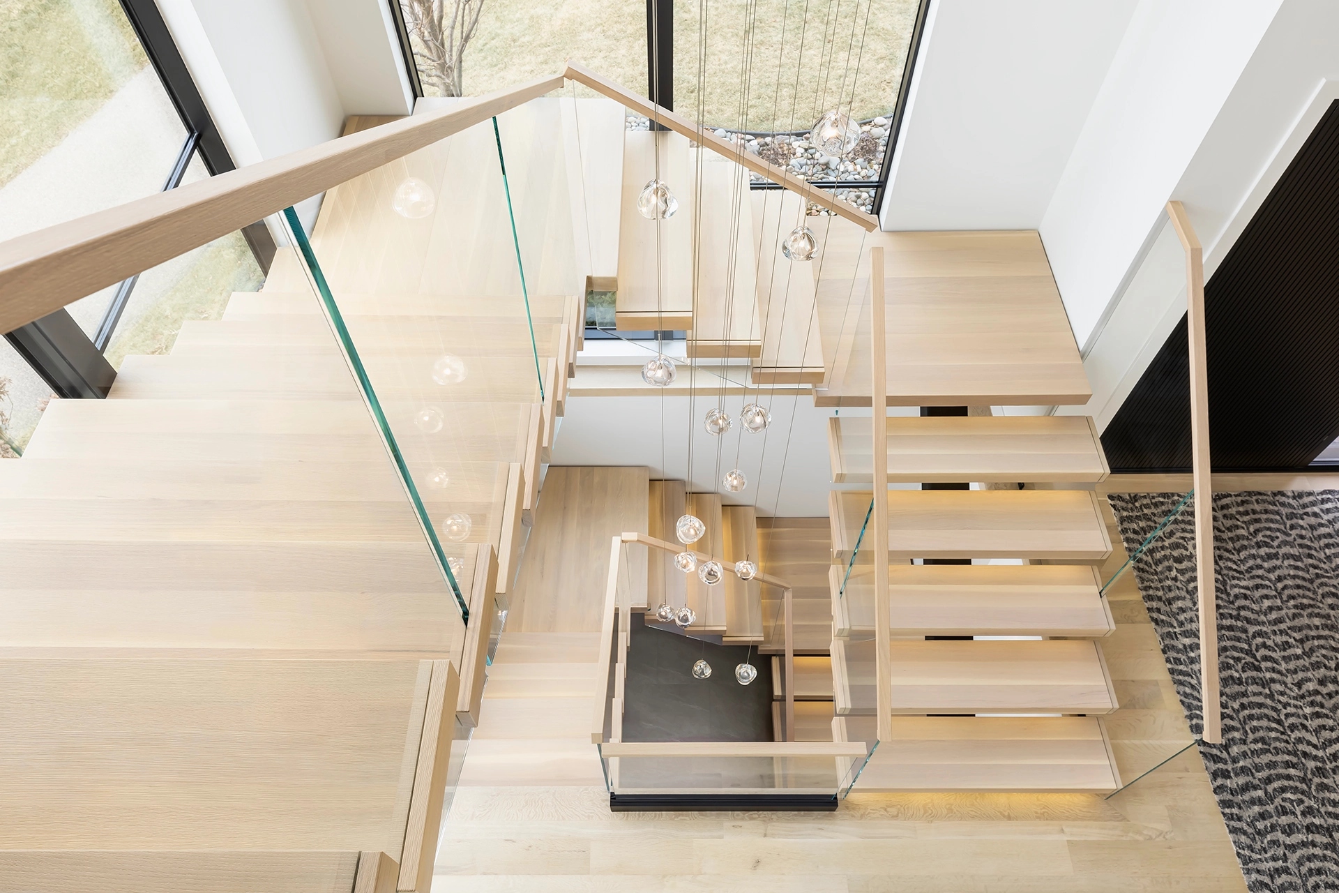 Multiple flights with glass railing climb beneath a long skylight
