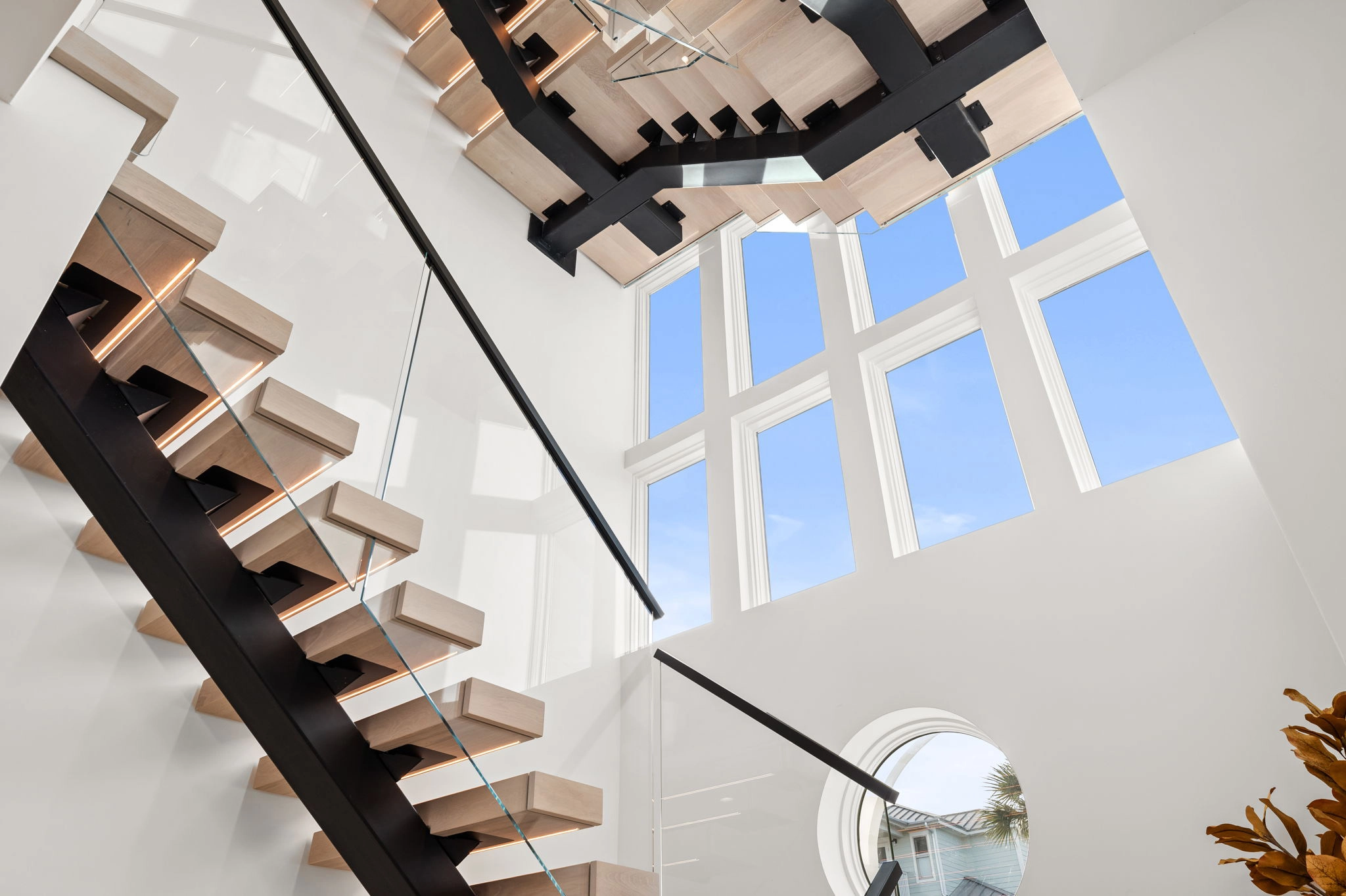 Looking up a stair where glass panels sit flush with each tread edge