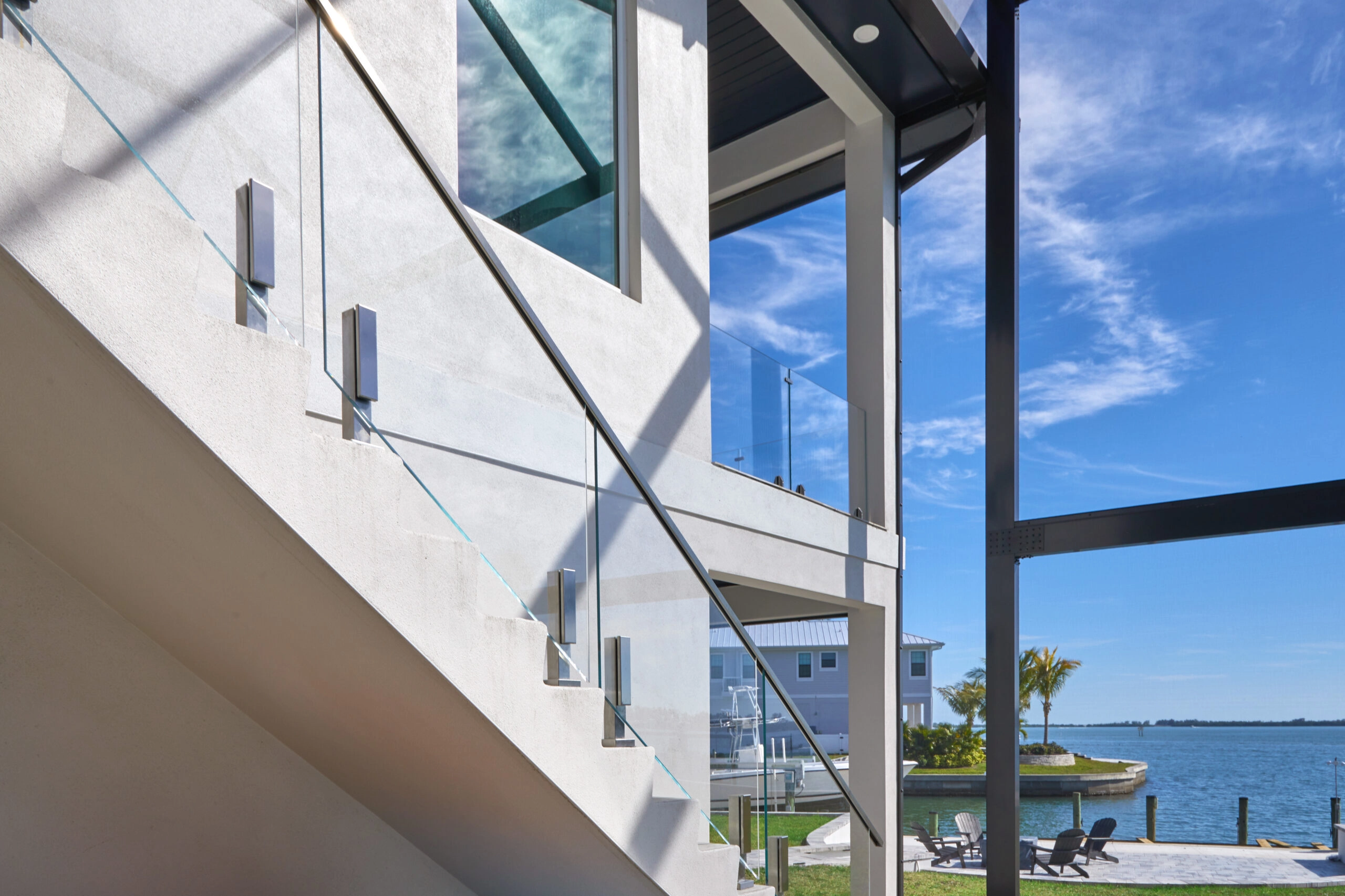Black spigots hold glass along a coastal balcony above open water